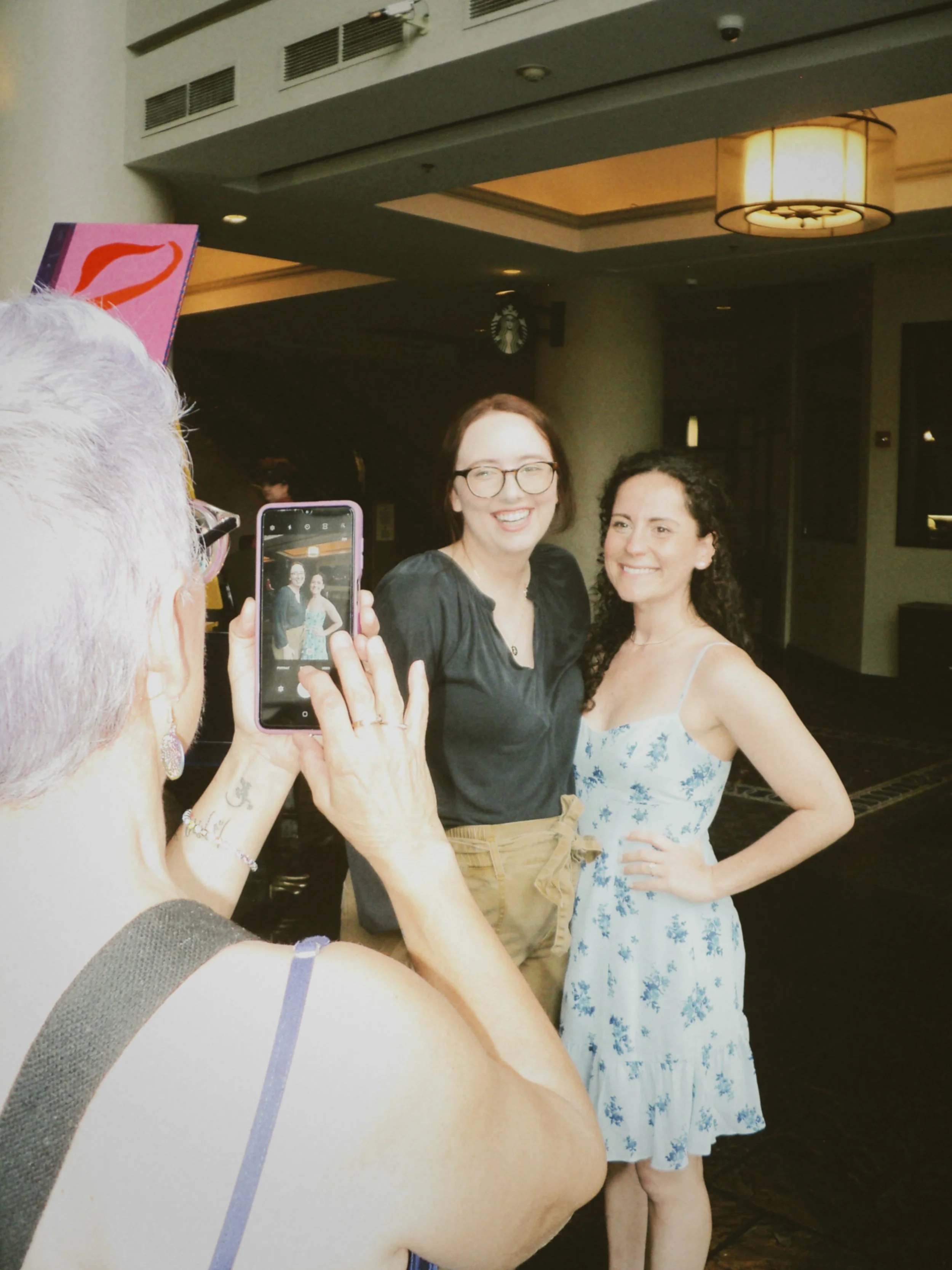 Two women posing for a photo together while celebrating with friends and family before the wedding.