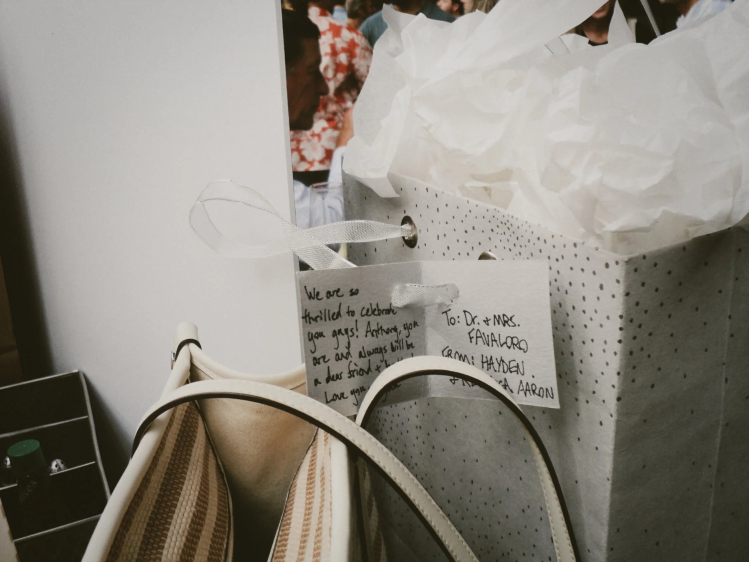 Close-up of gift bags and a handwritten card congratulating the couple before the wedding.