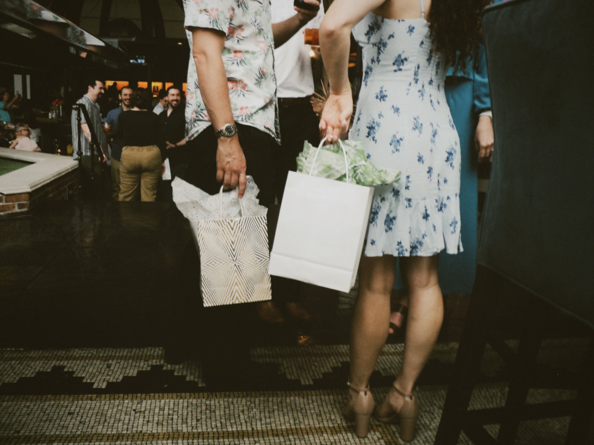 Guests carrying gift bags while mingling at the couple’s pre-wedding celebration.