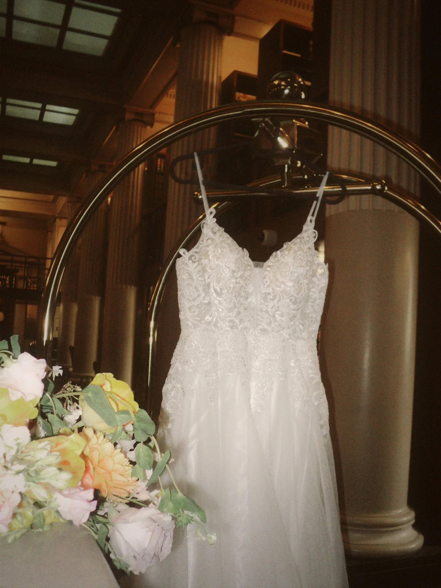 Lace wedding dress and colorful bridal bouquet photographed before a courthouse wedding