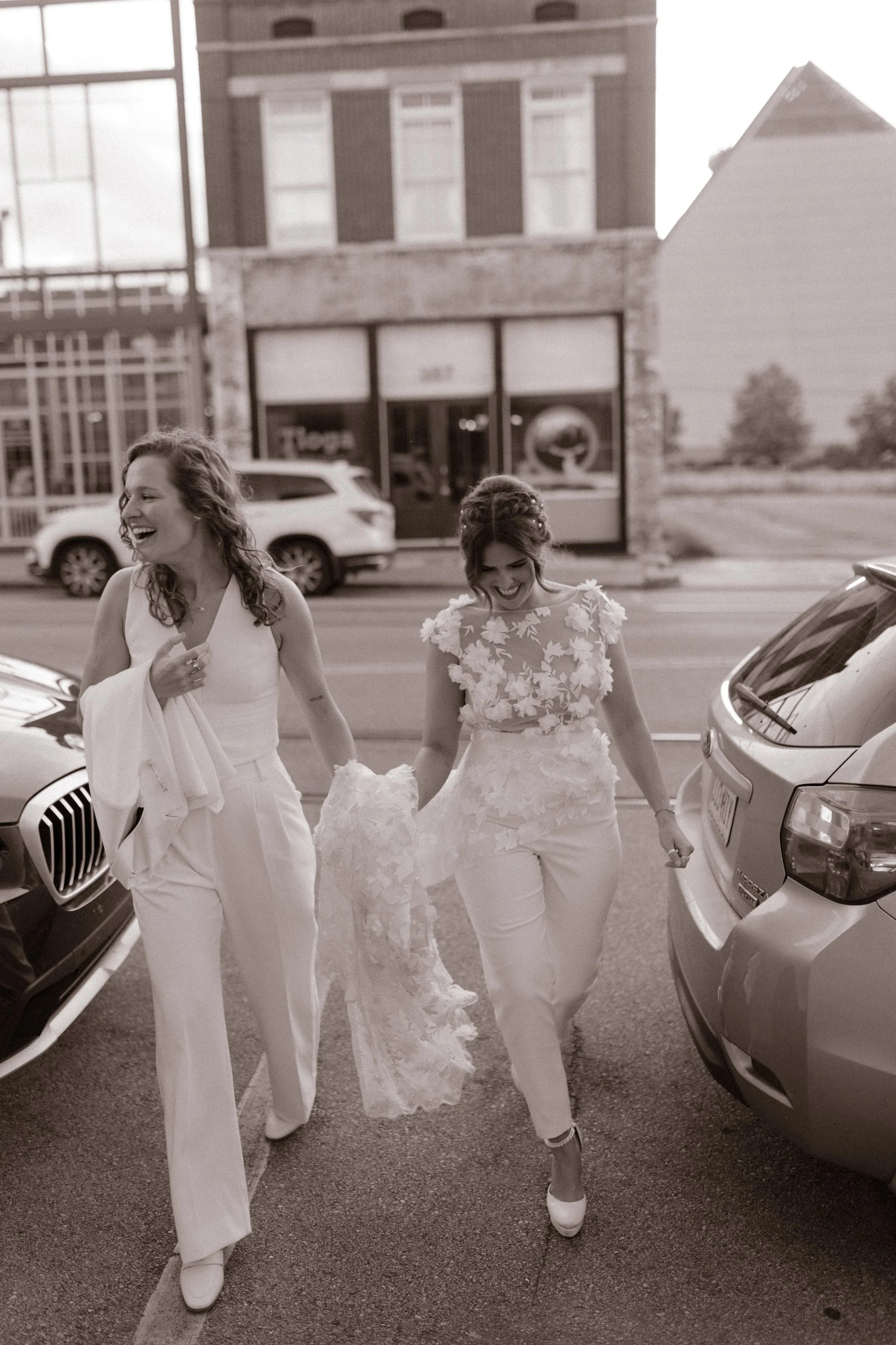 New York City courthouse wedding brides walking hand in hand in a lace dress and modern white suit