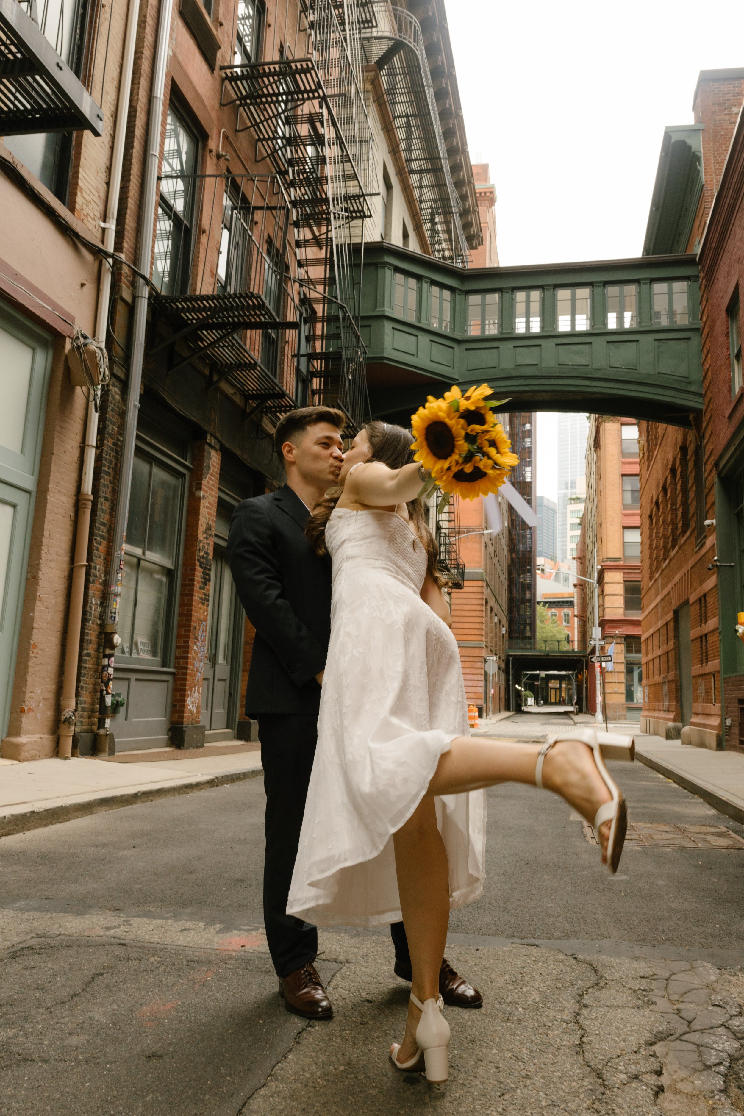Newlyweds adjusting a bridal veil together in front of a Manhattan apartment window