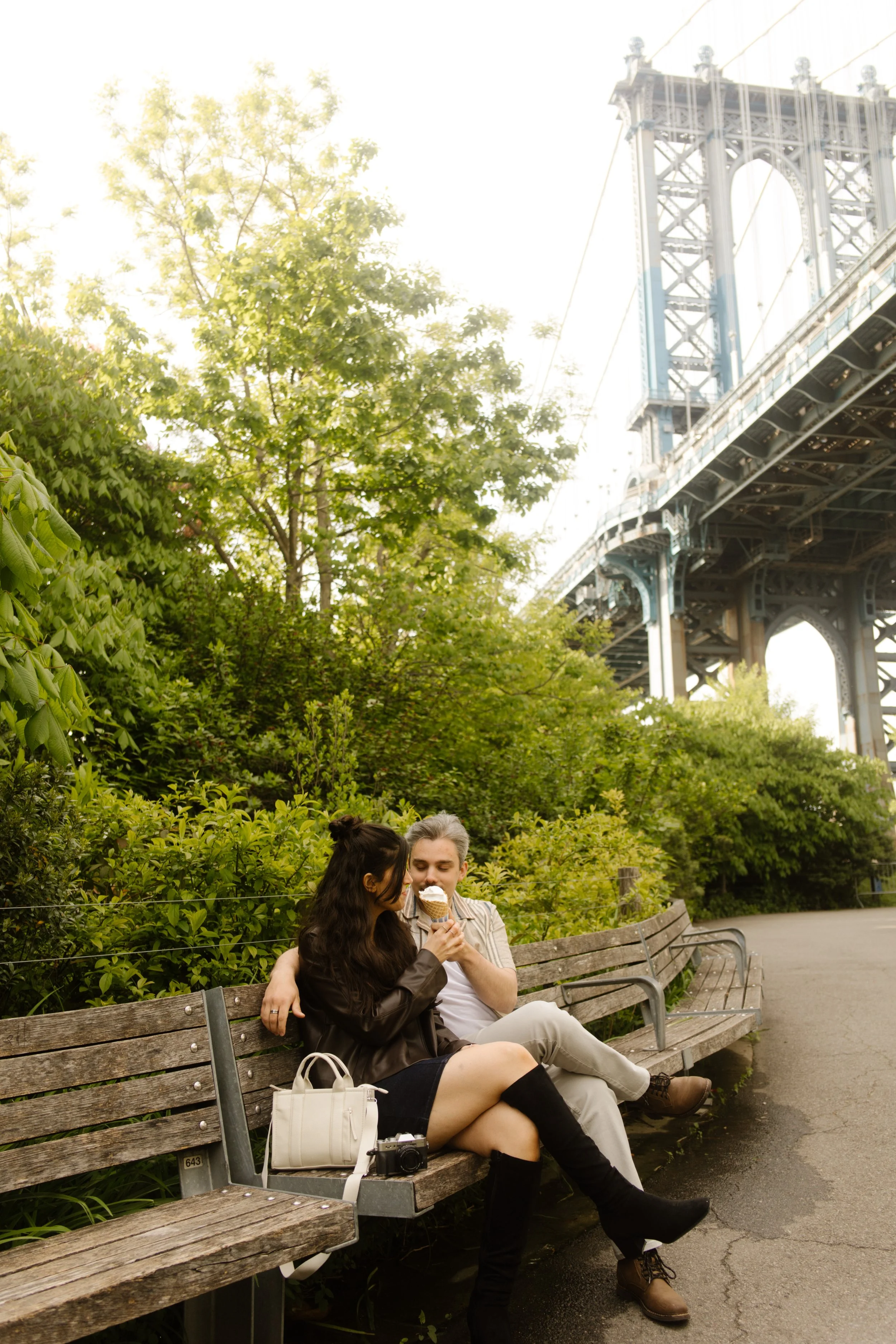 Couple sharing ice cream beneath the Manhattan Bridge, one of the most recognizable wedding locations in New York for relaxed portraits.