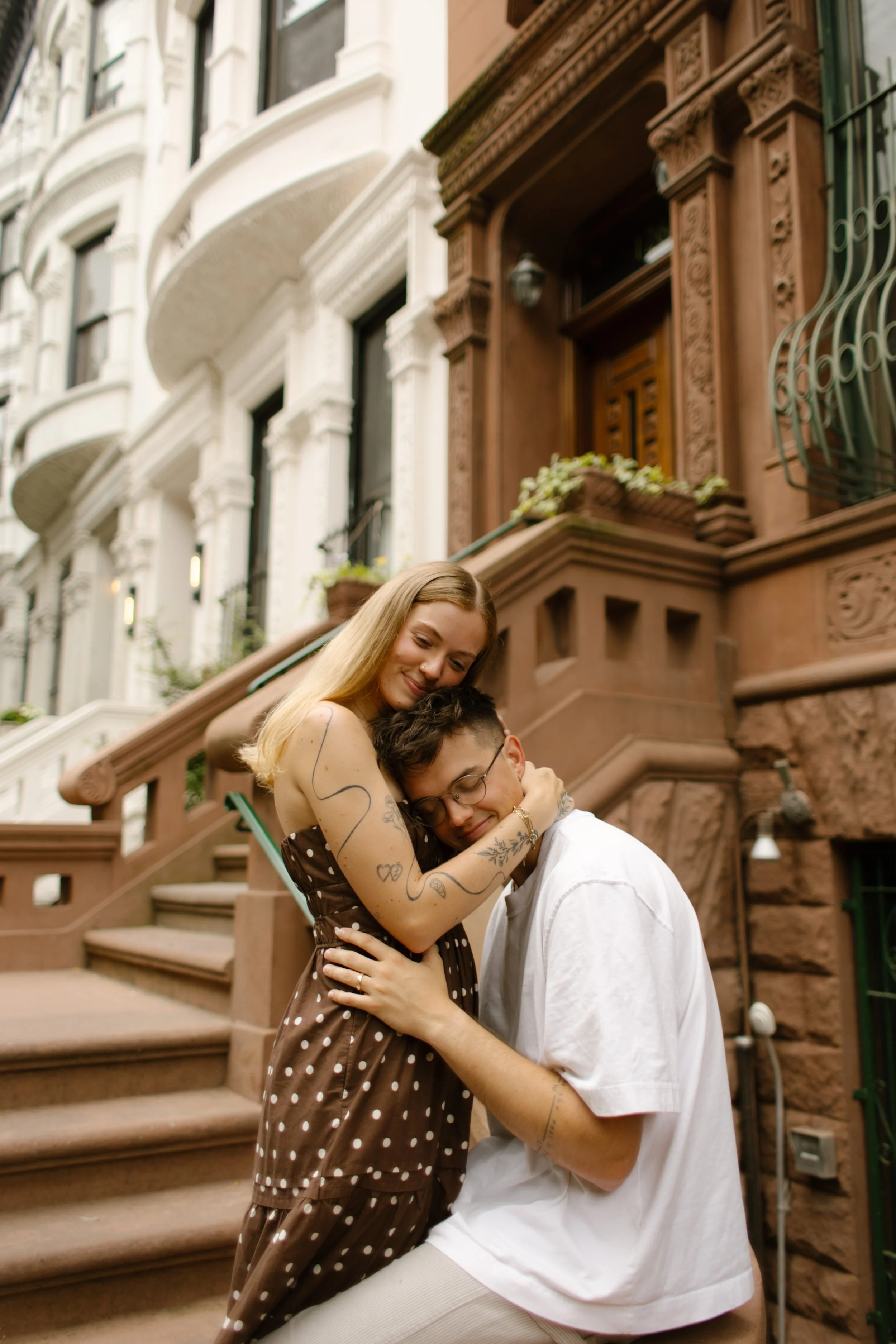 Couple embrace on a brownstone stoop during a romantic New York City portrait session.