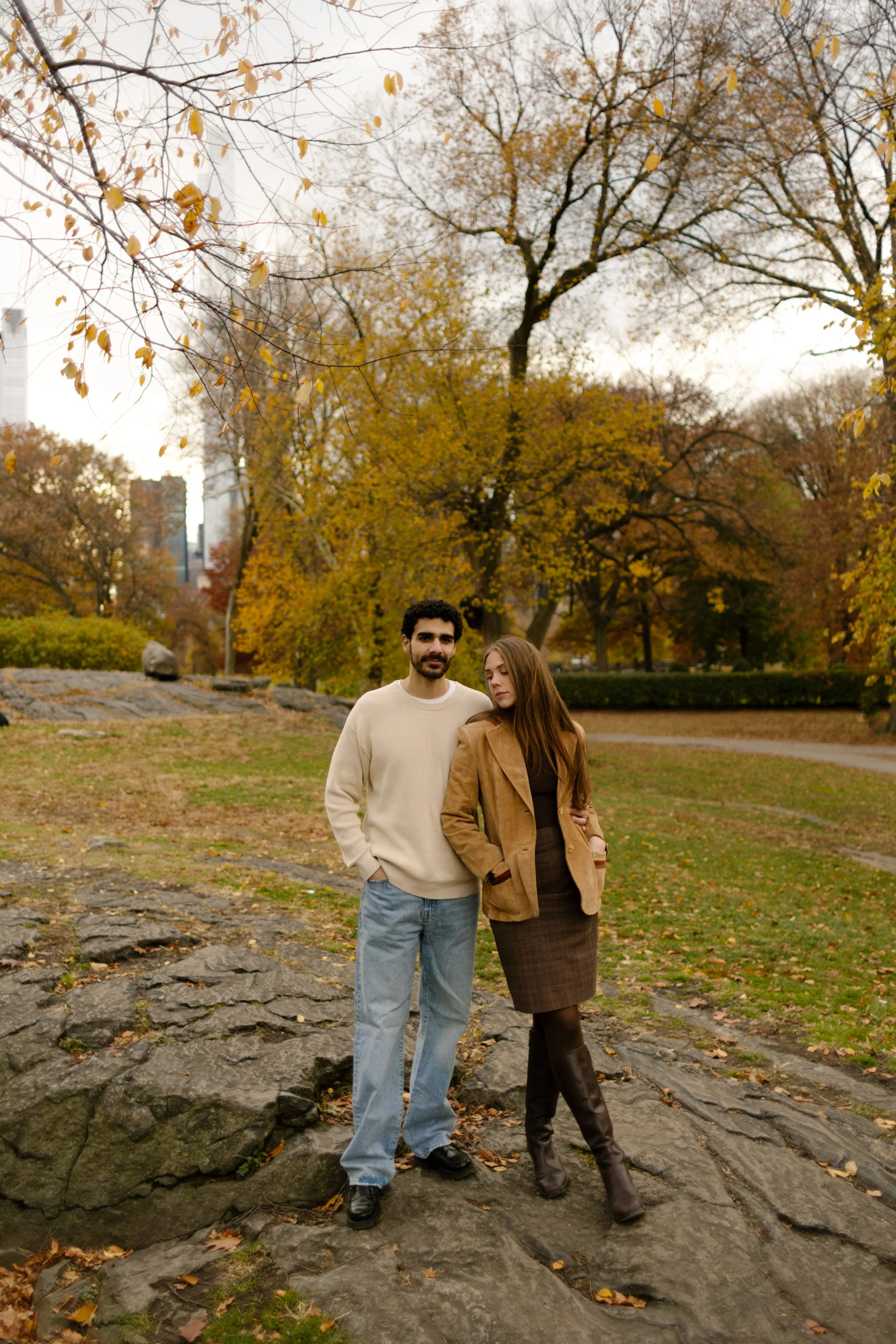 Couple pose together among colorful autumn trees during a New York City engagement session.