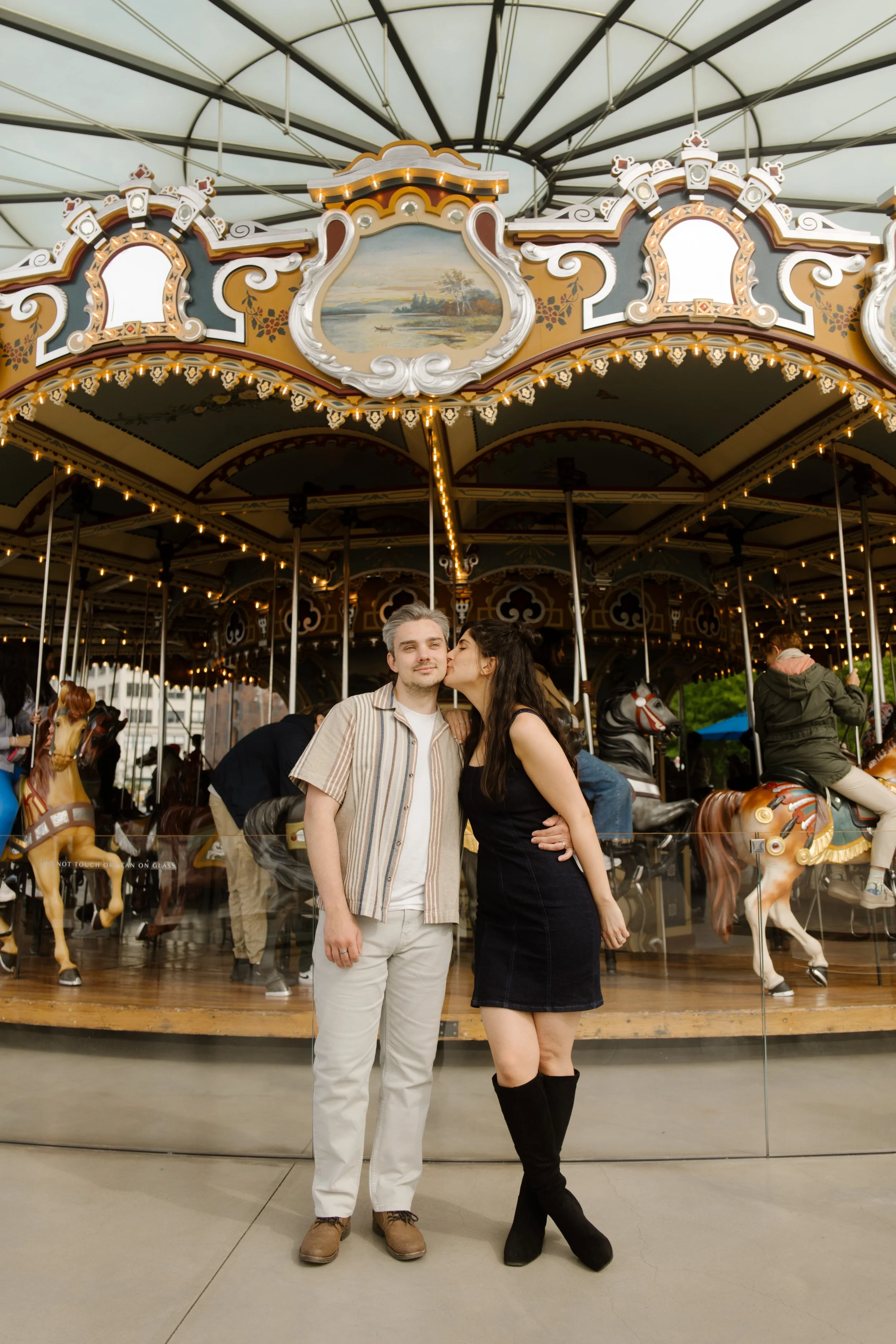 Couple pose in front of a vintage carousel, showcasing one of the playful wedding locations in New York.