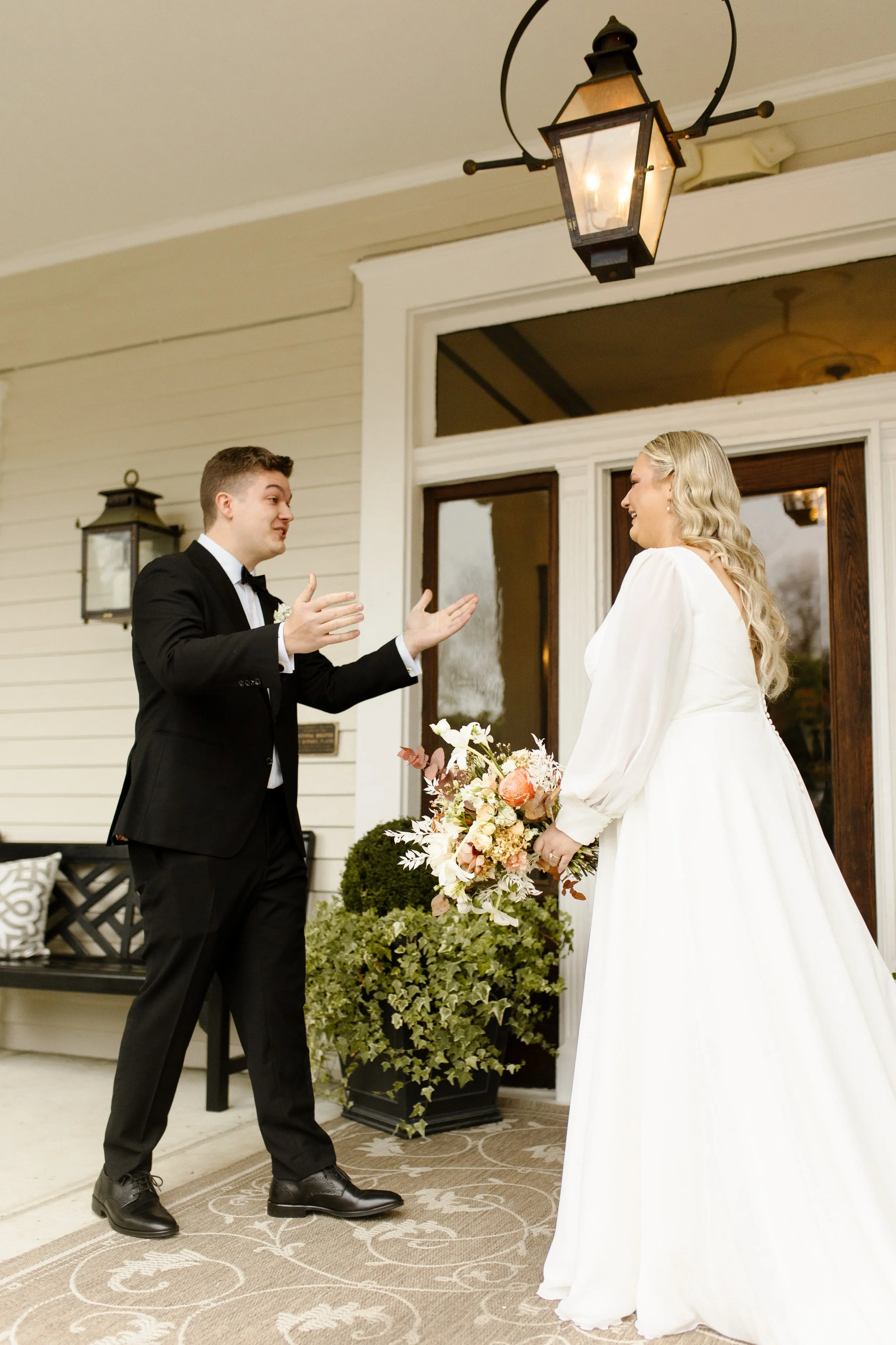 Groom reacting with open arms as he sees the bride for the first time before their fall wedding ceremony.
