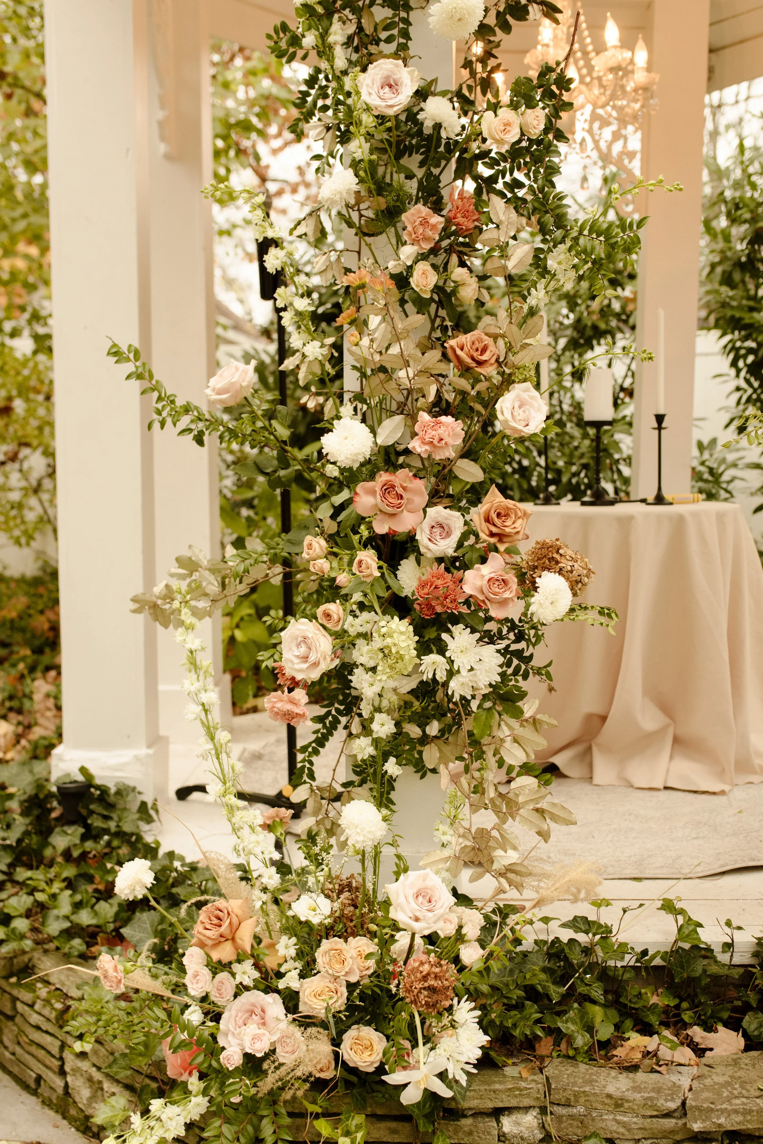 Peach, blush, and white floral installation decorating the gazebo for an outdoor fall wedding ceremony.