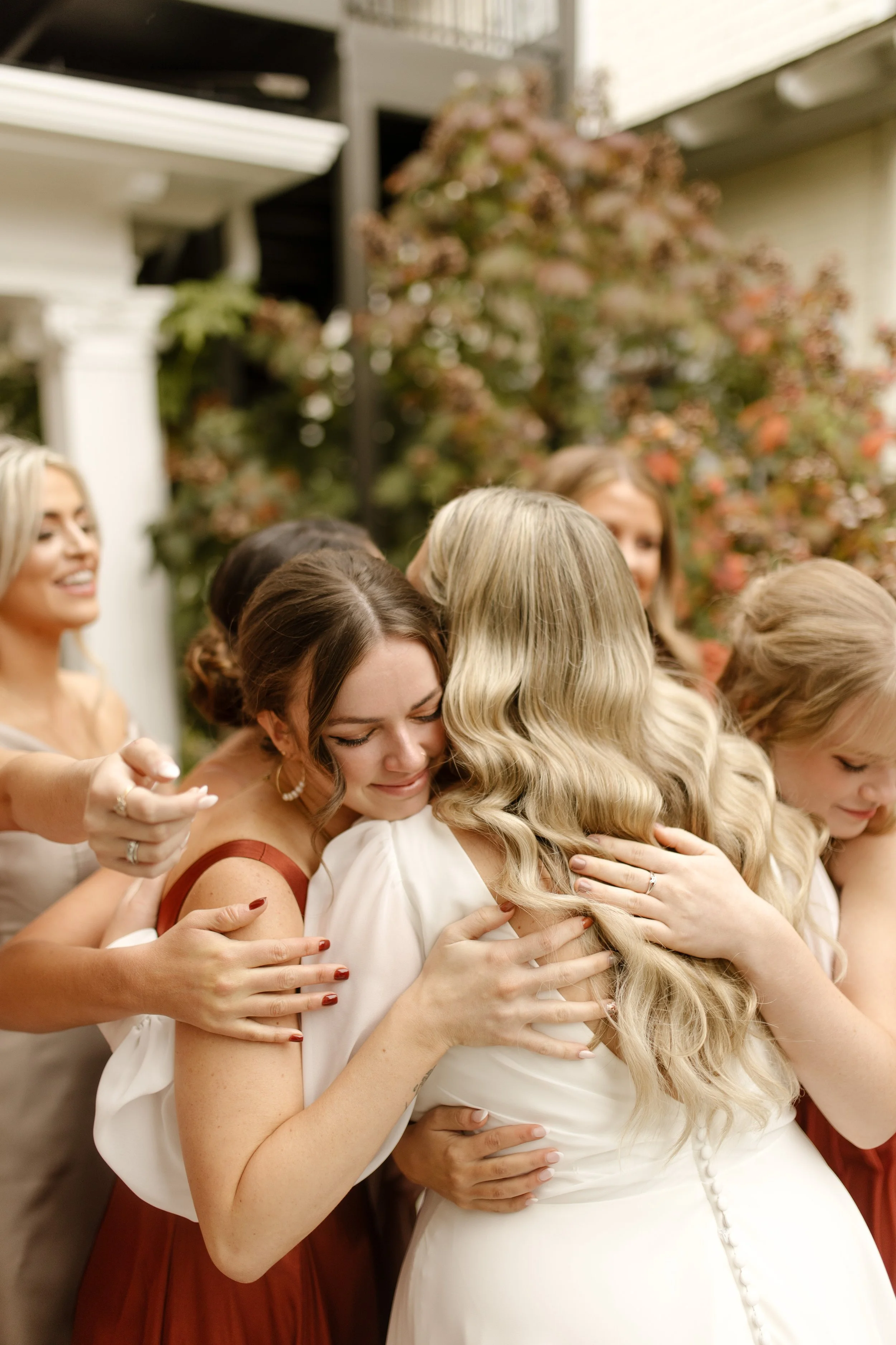 Bridesmaid hugging the bride after the ceremony during an emotional fall wedding moment.
