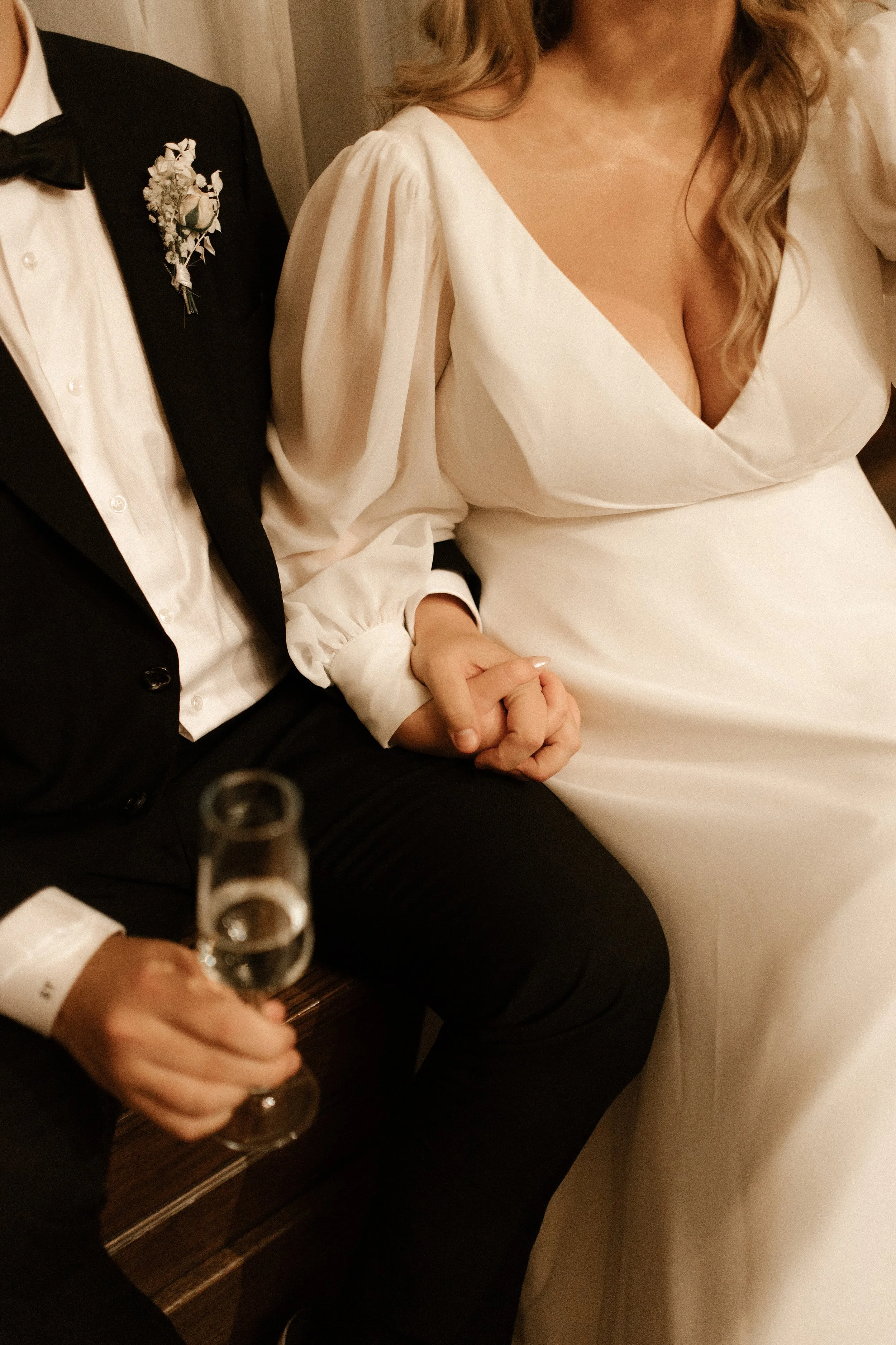 Close-up of newlyweds holding hands together during their intimate wedding celebration.