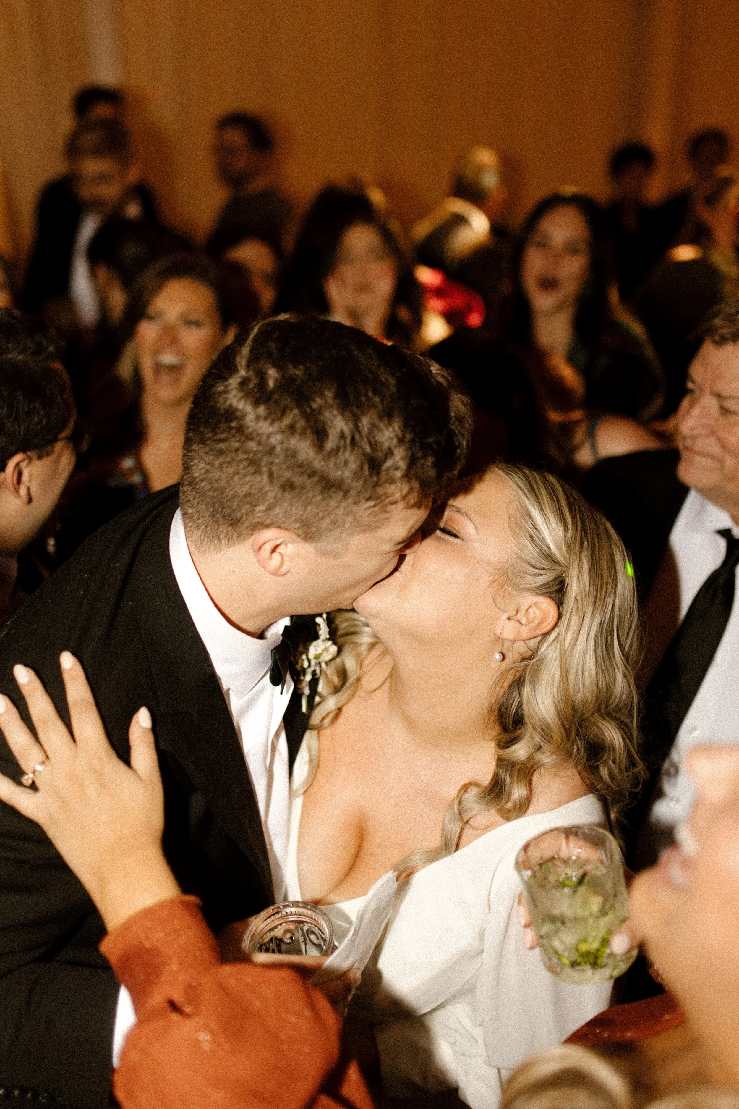 Bride and groom sharing a kiss on the dance floor during their joyful fall wedding reception.