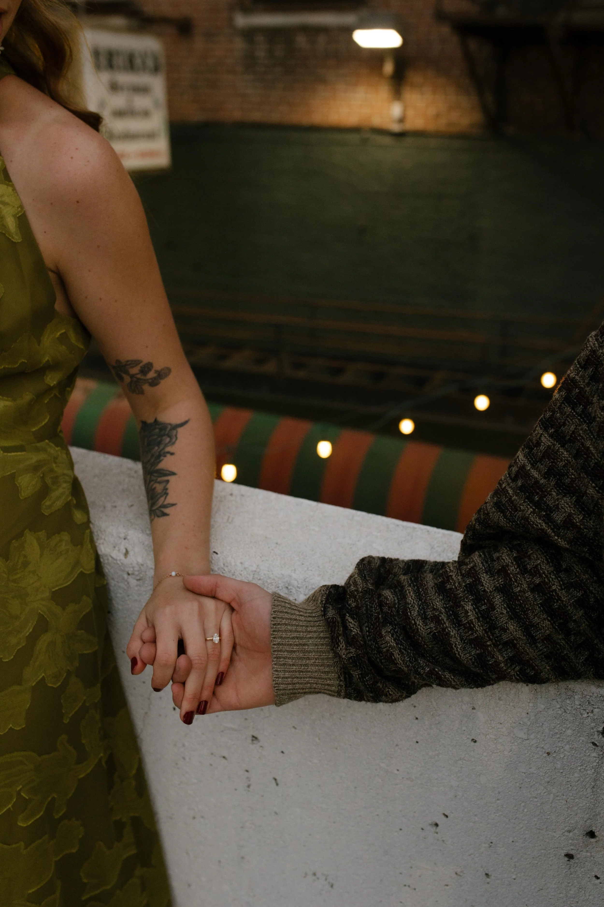 Close-up of an engaged couple holding hands during engagement photos in NYC, highlighting her engagement ring.