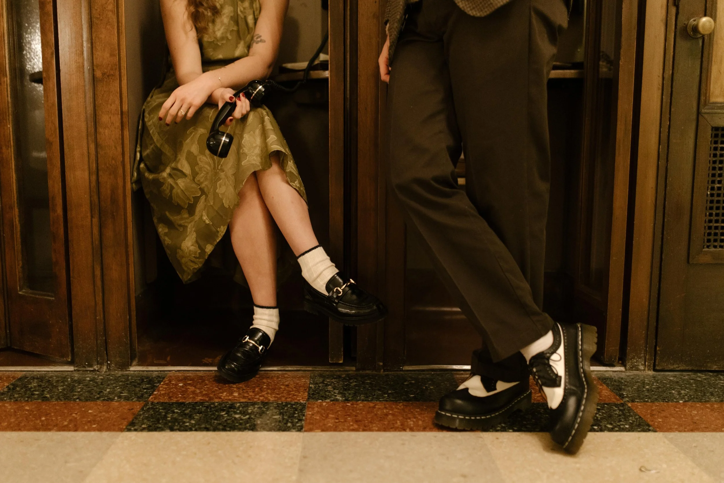 Stylish details from engagement photos in NYC, featuring the couple’s vintage-inspired shoes and outfits inside wood-paneled booths.