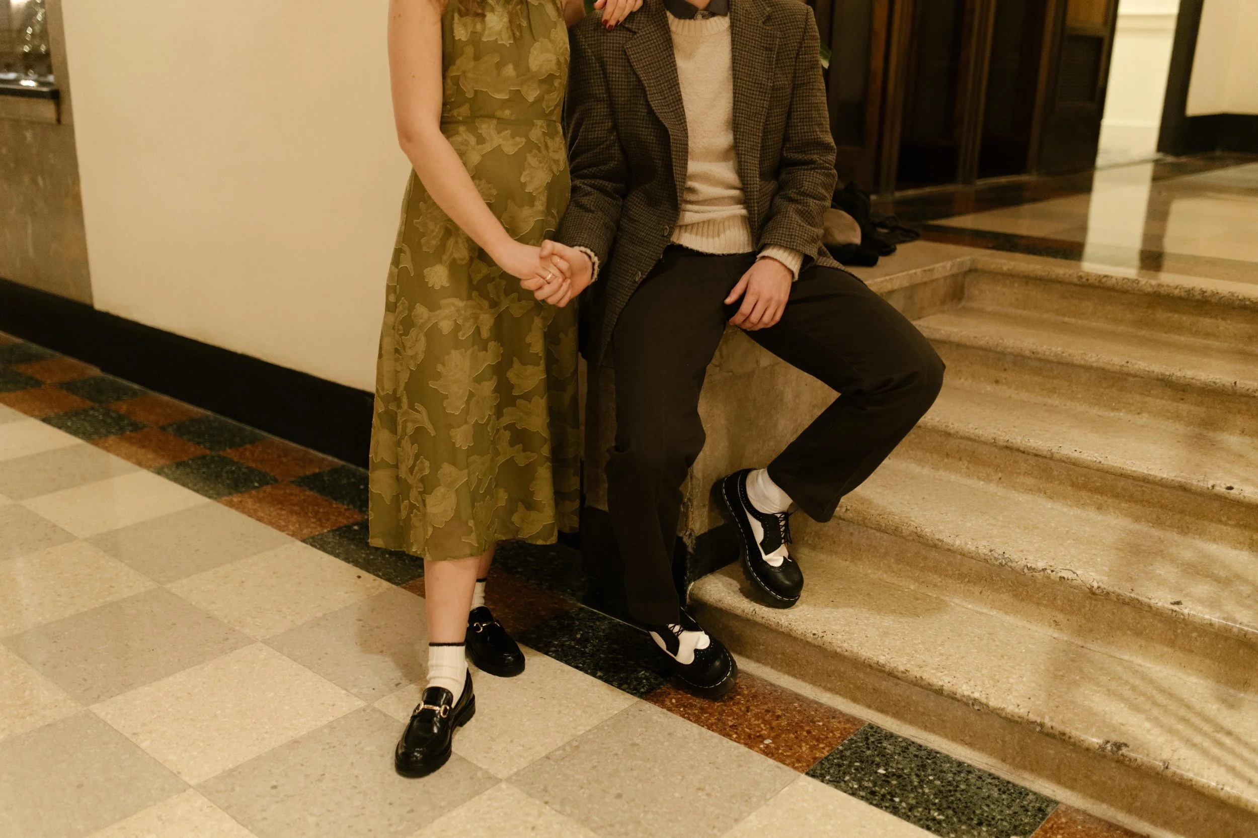 Stylish detail from engagement photos in NYC featuring the couple holding hands in vintage-inspired outfits and black shoes.
