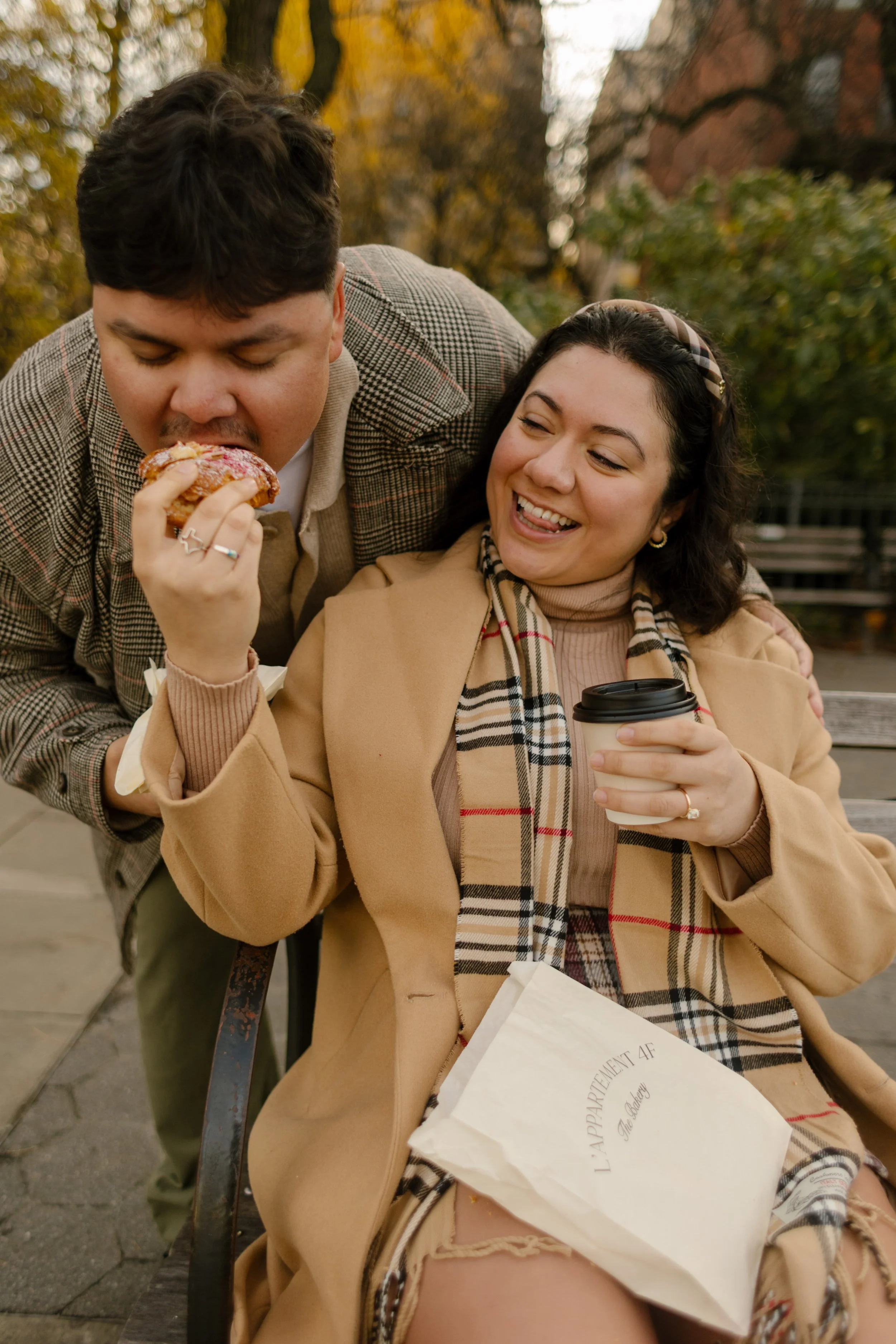 1. Candid fall engagement photo of a couple laughing while sharing a pastry and coffee during their Brooklyn date.