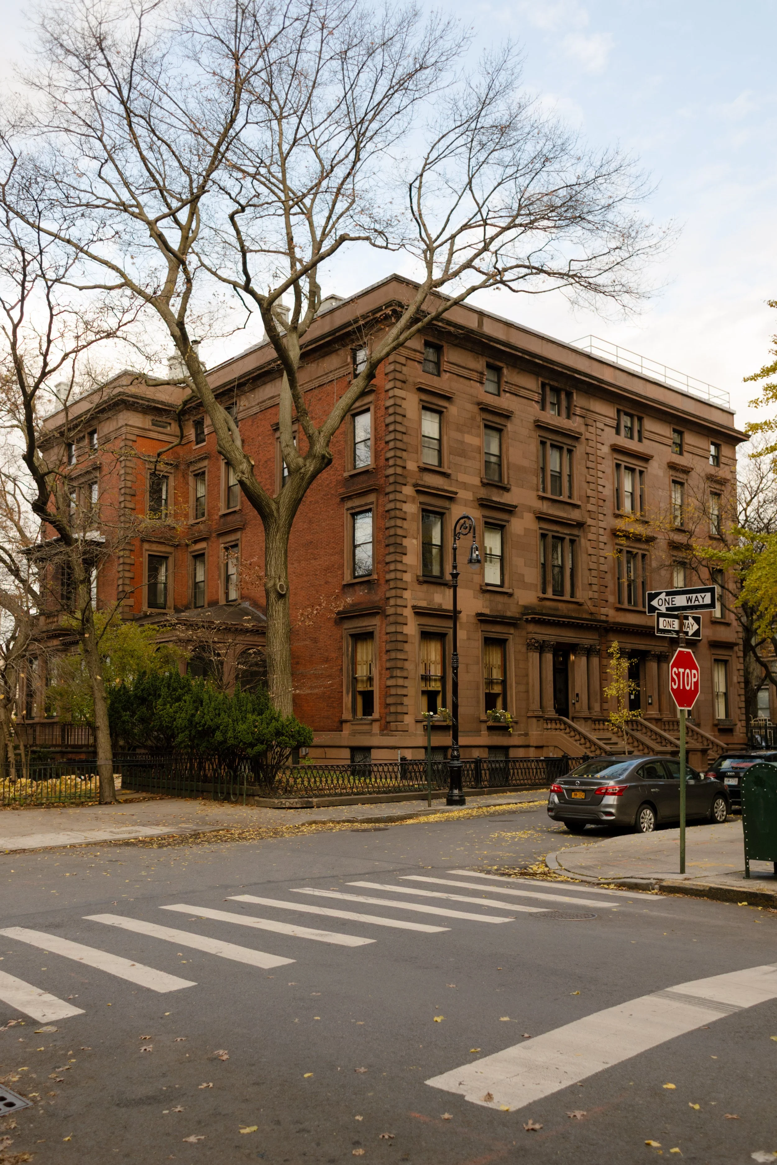 Quiet Brooklyn Heights street corner with historic brownstones, bare fall trees, and classic neighborhood architecture.