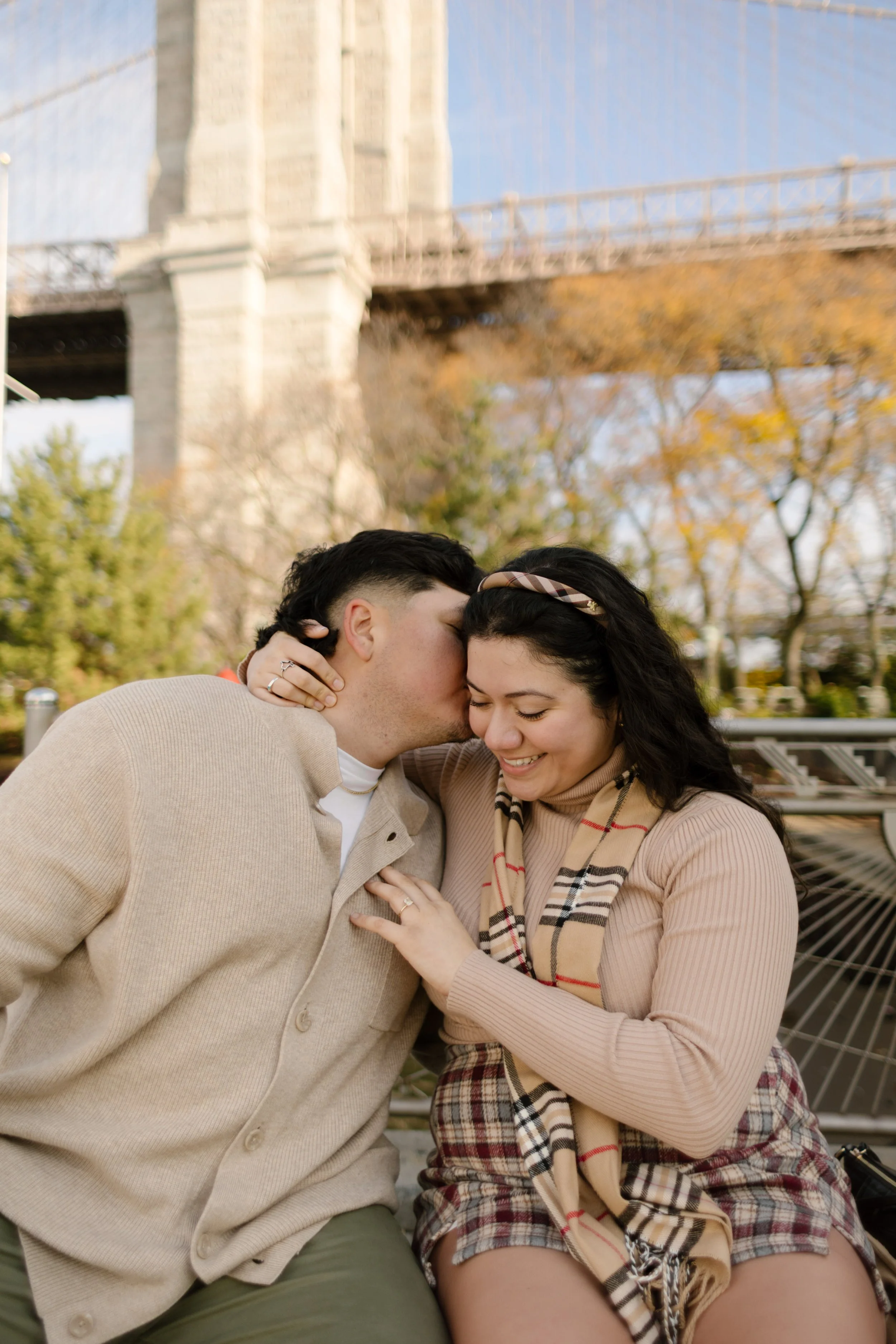 Brooklyn engagement photos of a couple laughing together near the Brooklyn Bridge during a relaxed fall session.