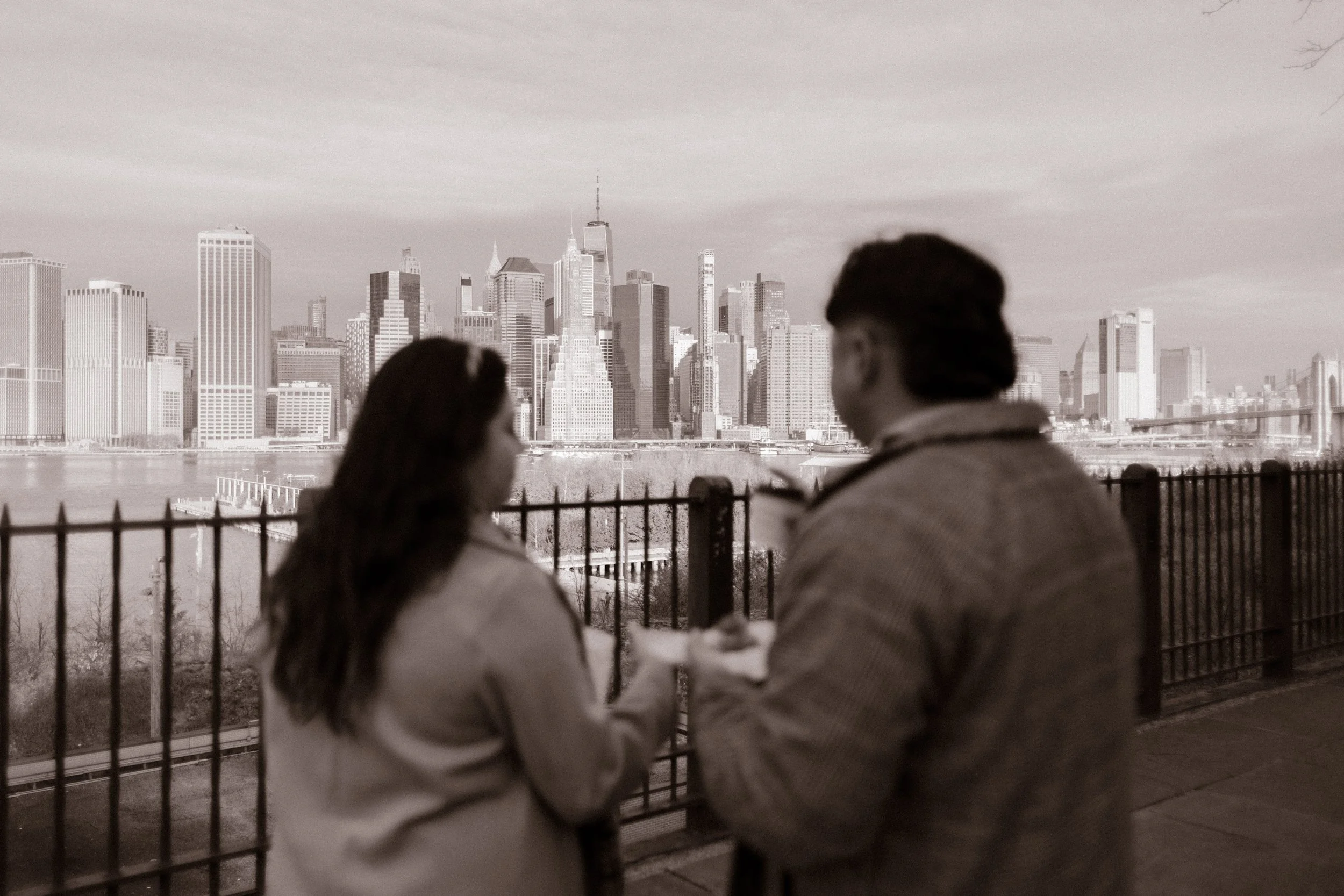 Brooklyn engagement photos in black and white of a couple sharing coffee while looking out at the Manhattan skyline.