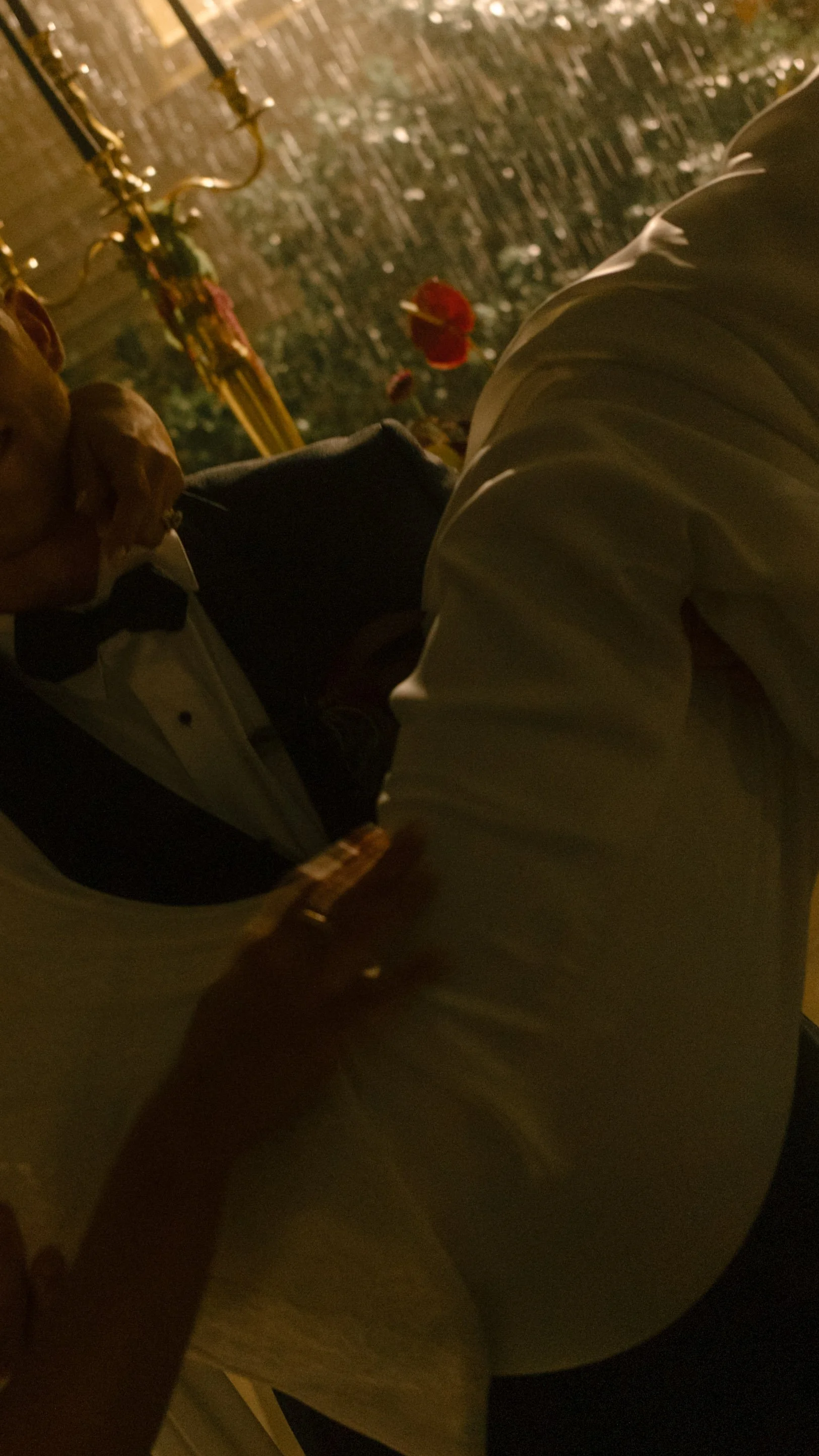 Intimate nighttime wedding photograph of the couple embracing beneath warm reception lighting.