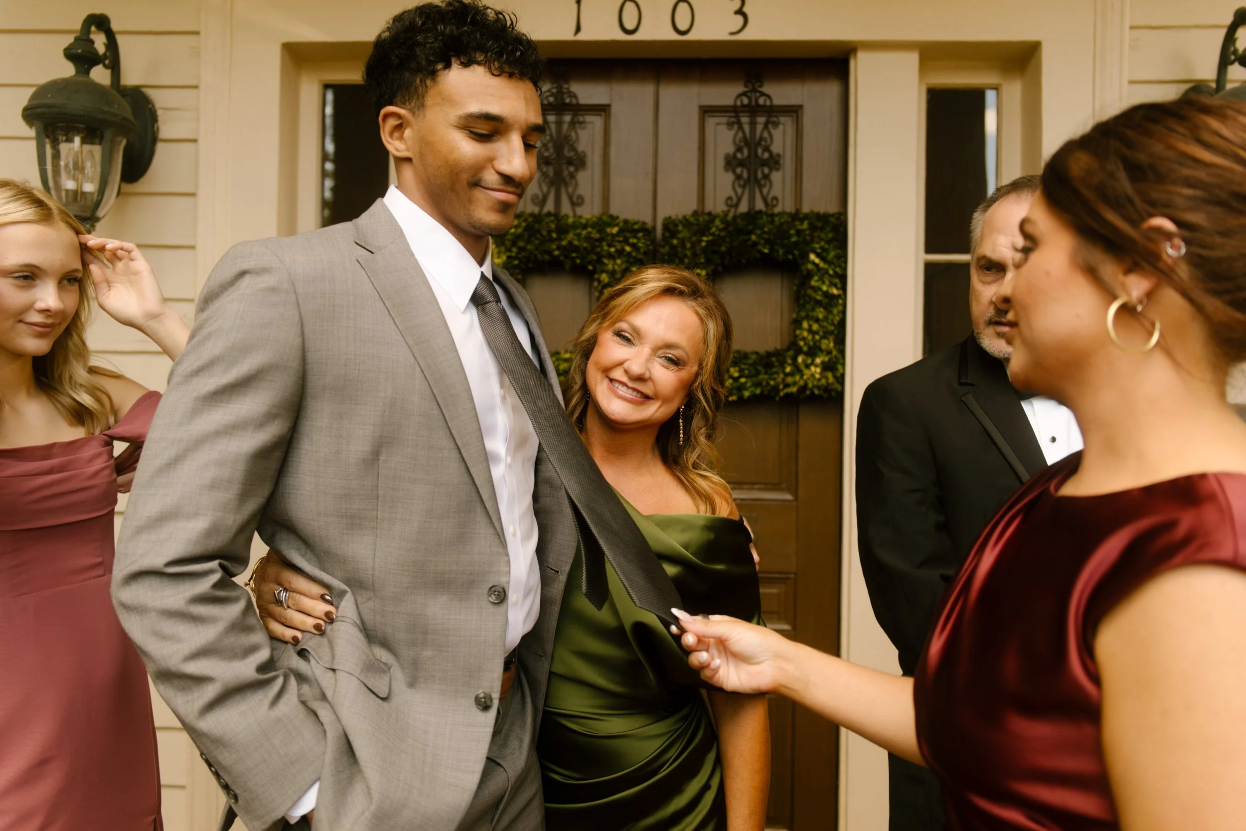 Candid wedding party moment with guests laughing together outside a historic wedding venue.