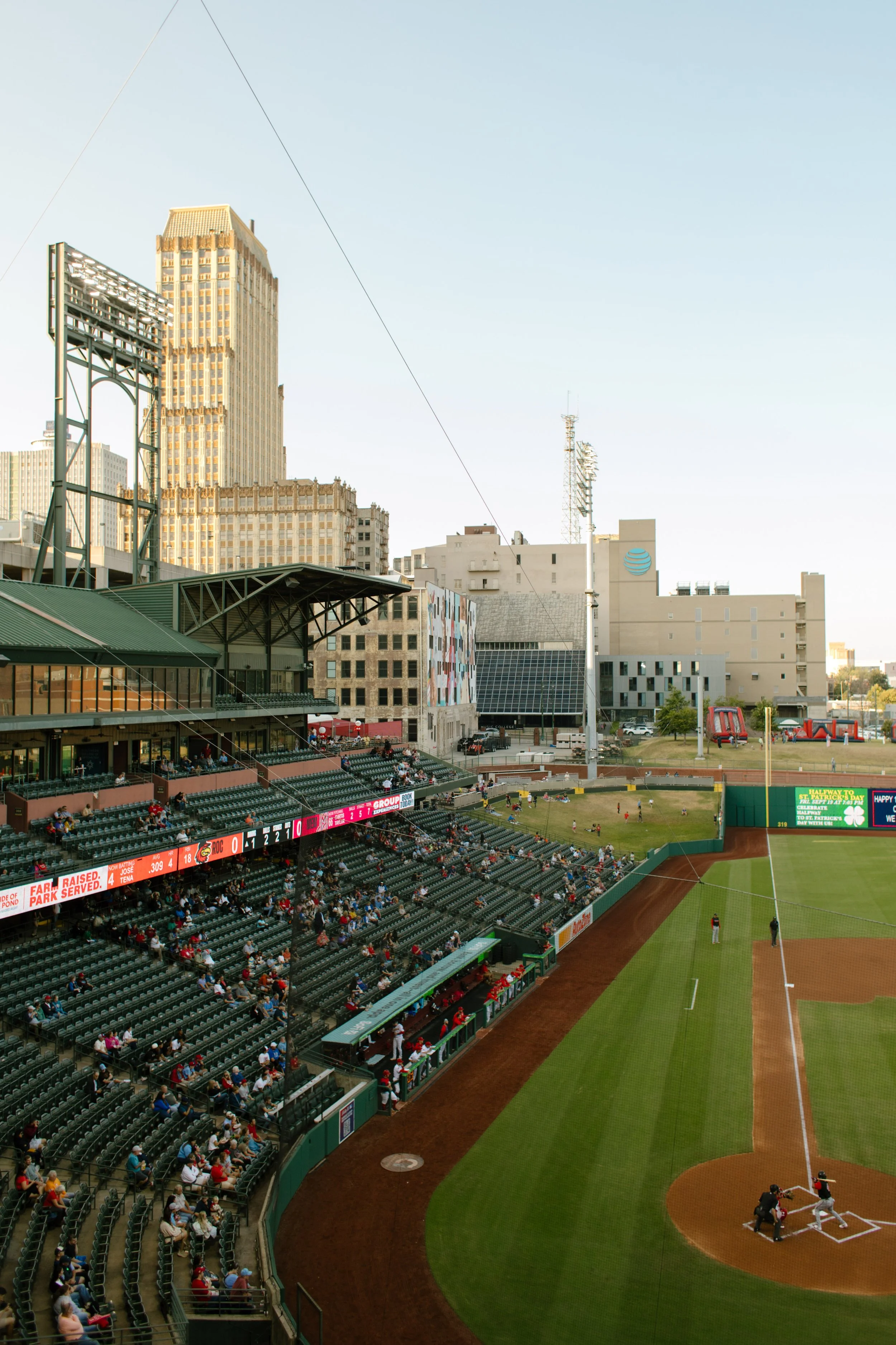 Elevated view of a baseball stadium at golden hour, with city buildings and the field providing inspiration for fun engagement photos.
