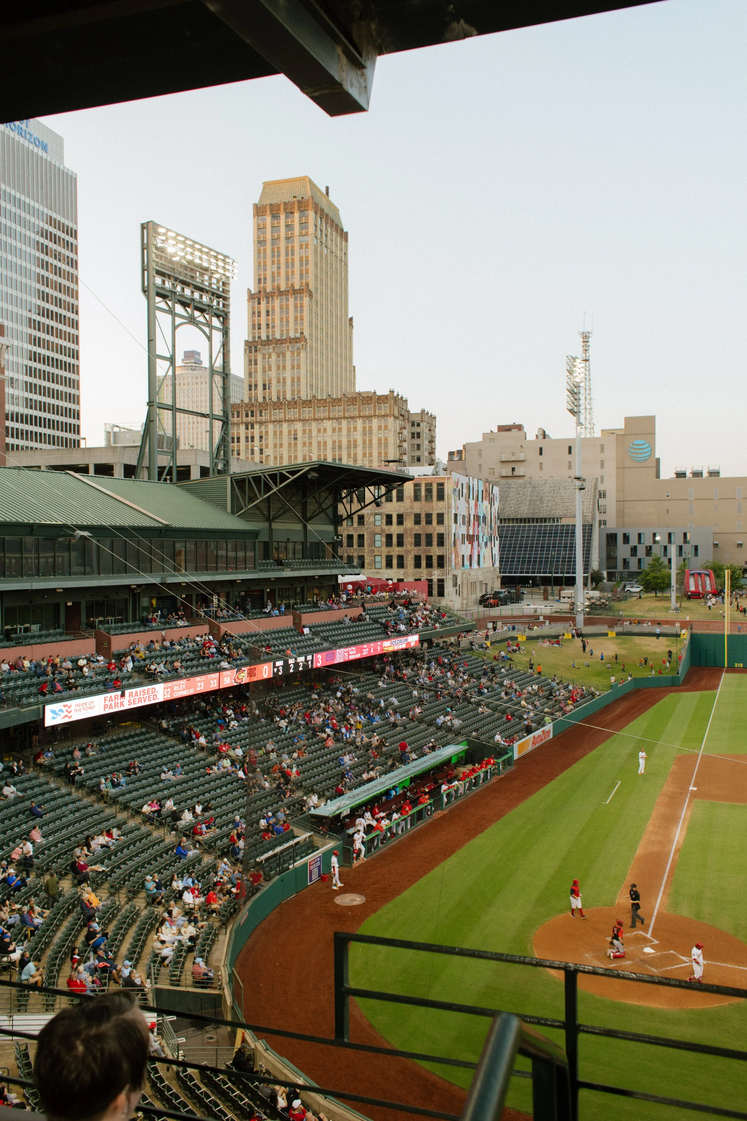 Elevated view of a baseball game at sunset, with the stadium and surrounding city buildings providing inspiration for fun engagement photos.