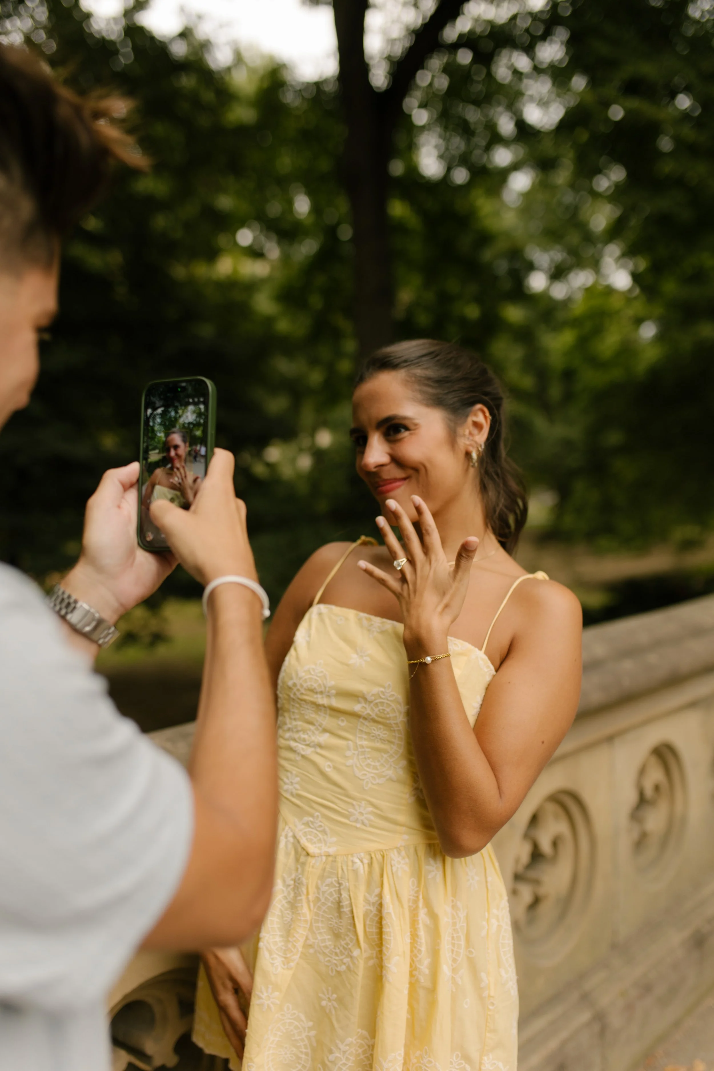 Sienna excitedly shows off her engagement ring while Chris photographs her with his phone following their new york proposal.