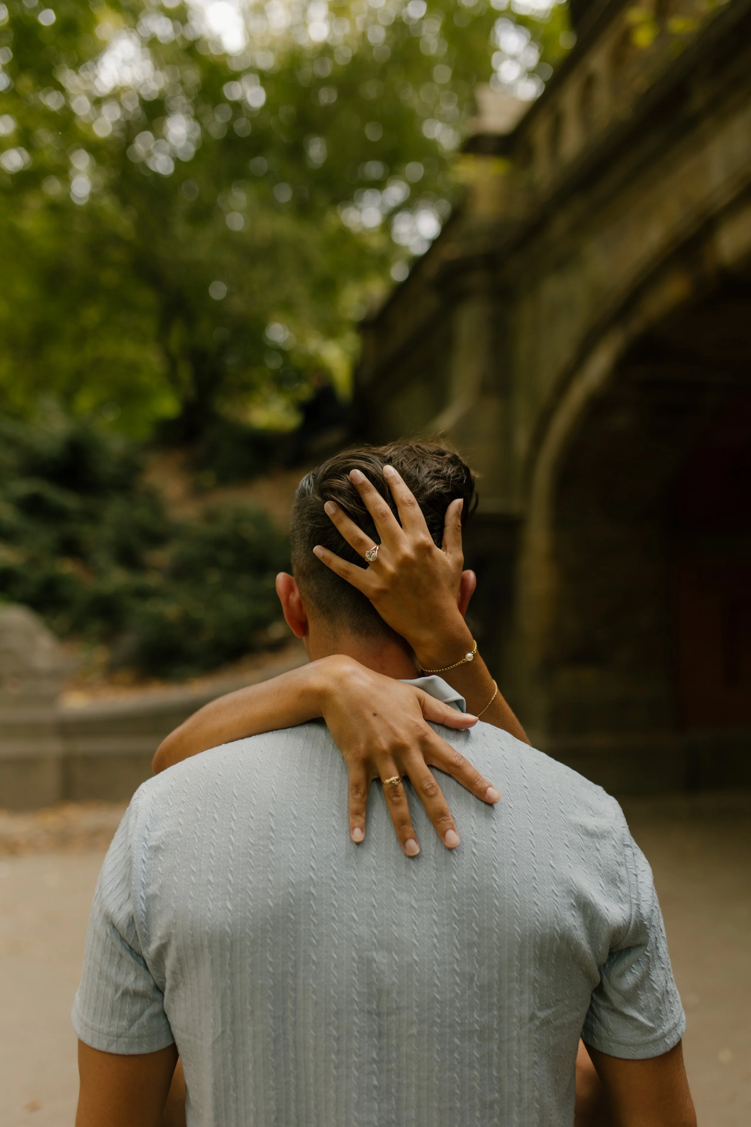 Close-up of Sienna embracing Chris with her engagement ring visible against the back of his head following their romantic new york proposal.
