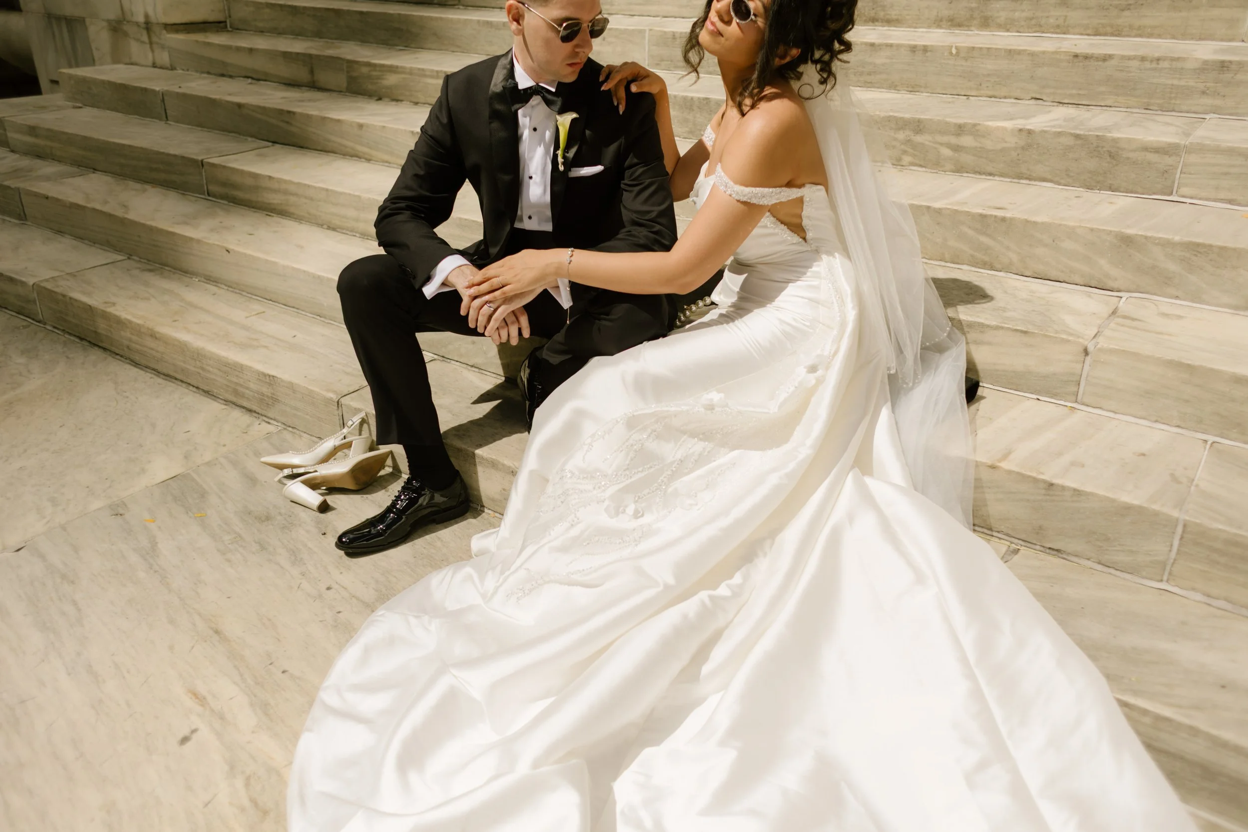 Newlyweds relax together on grand marble steps, featuring timeless Wedding Locations in NYC.
