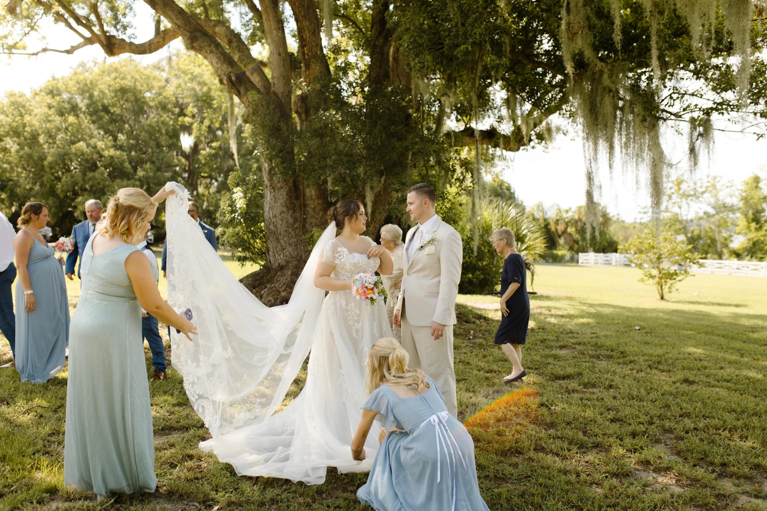 Wedding weekend chaos and love collide as family helps with final touches before the ceremony under a towering oak tree.