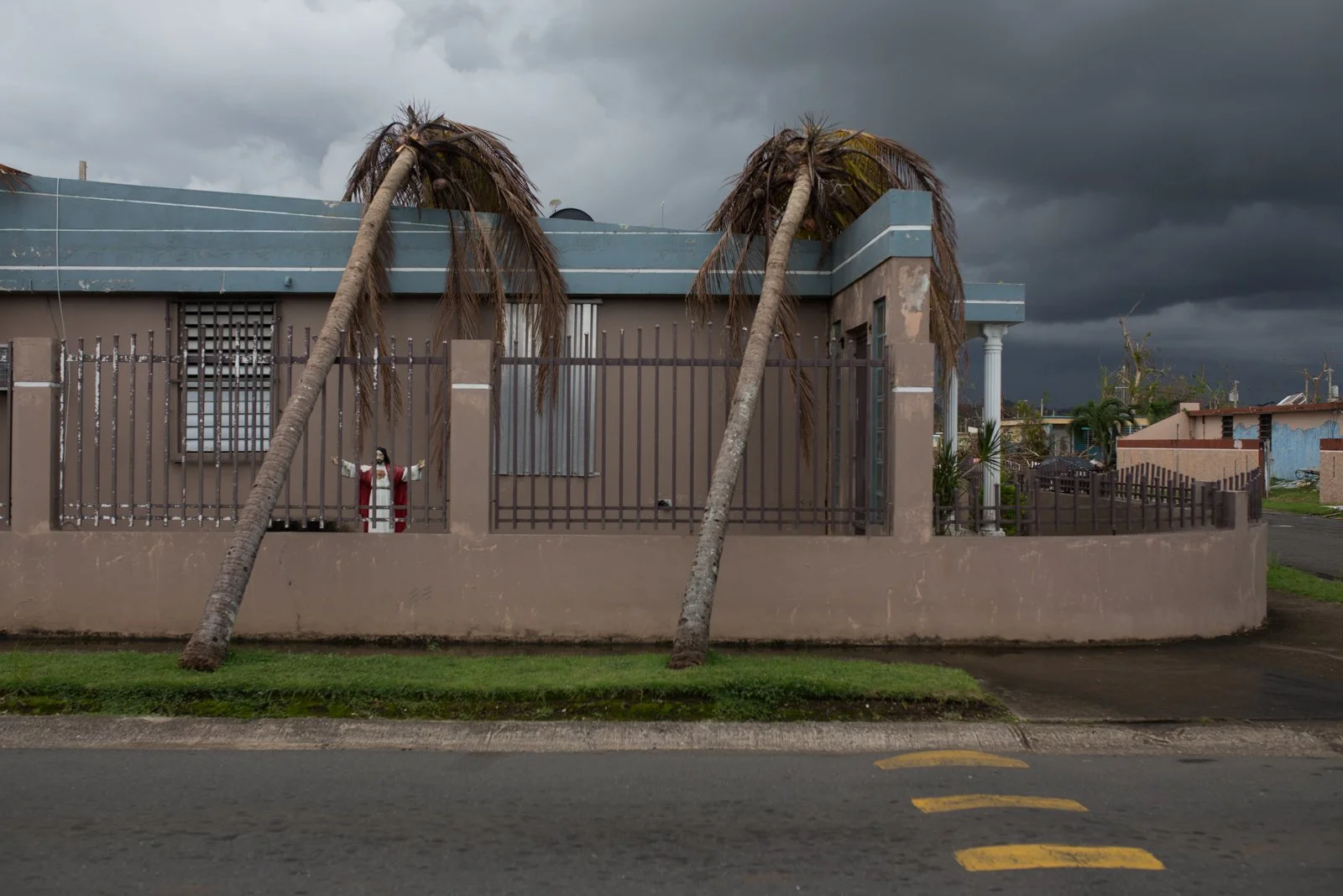 Palm trees rest against a house after hurricane Maria hit Puerto Rico in 2017.