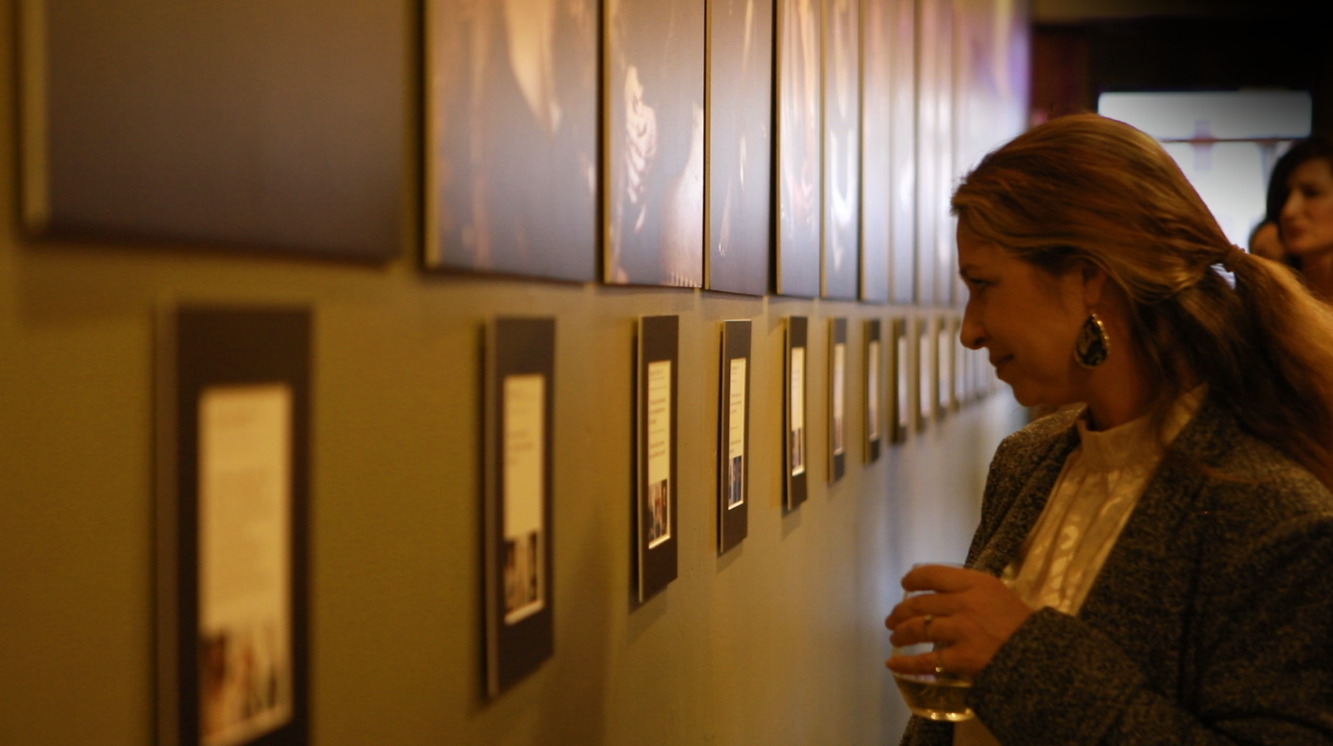 Women looking at portraits at the 40 Over 40 exhibition