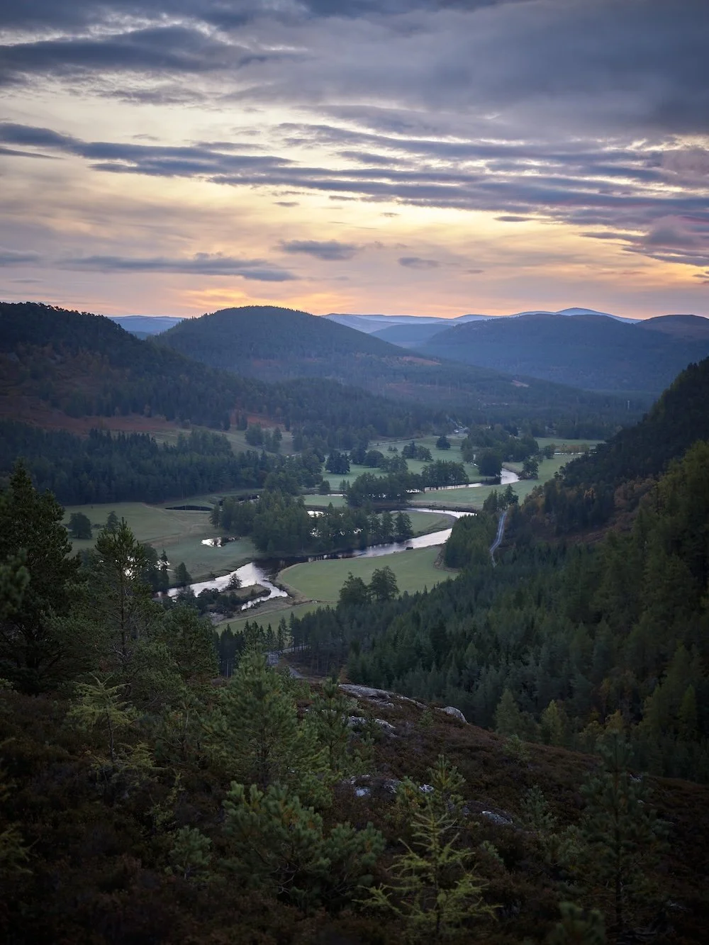 The village of Braemar, photographed under an early morning peach sky, the mountains of the surrounding national park rising in the background