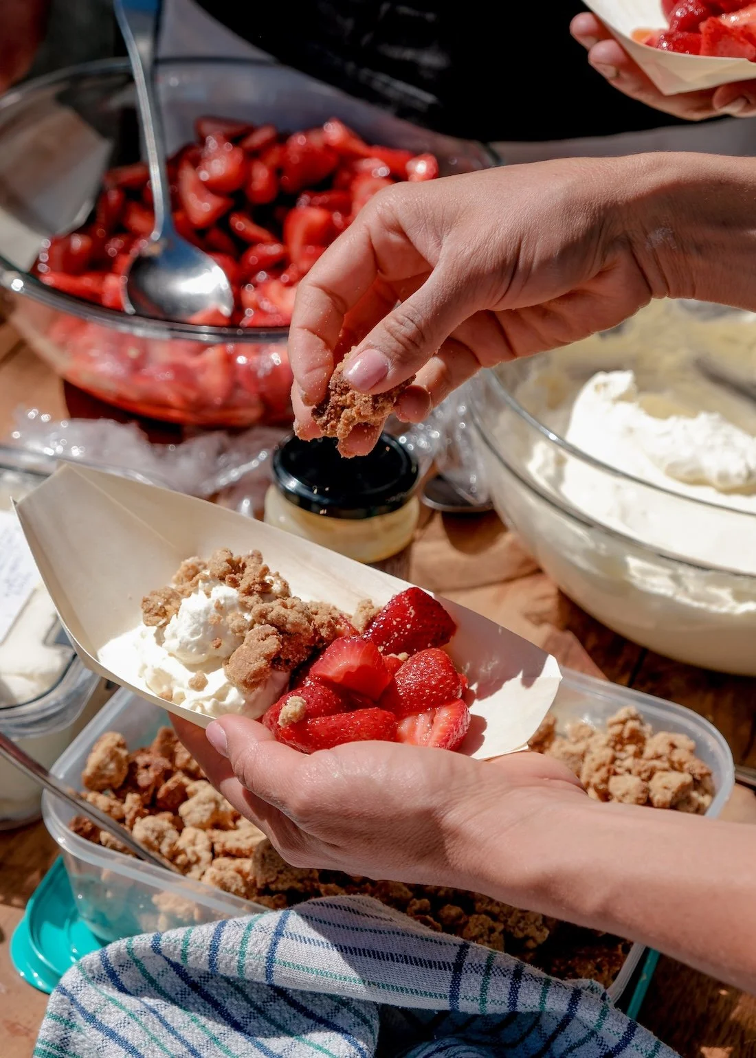 A close up of check Nadia Lim's hand as she prepares a strawberry crumble