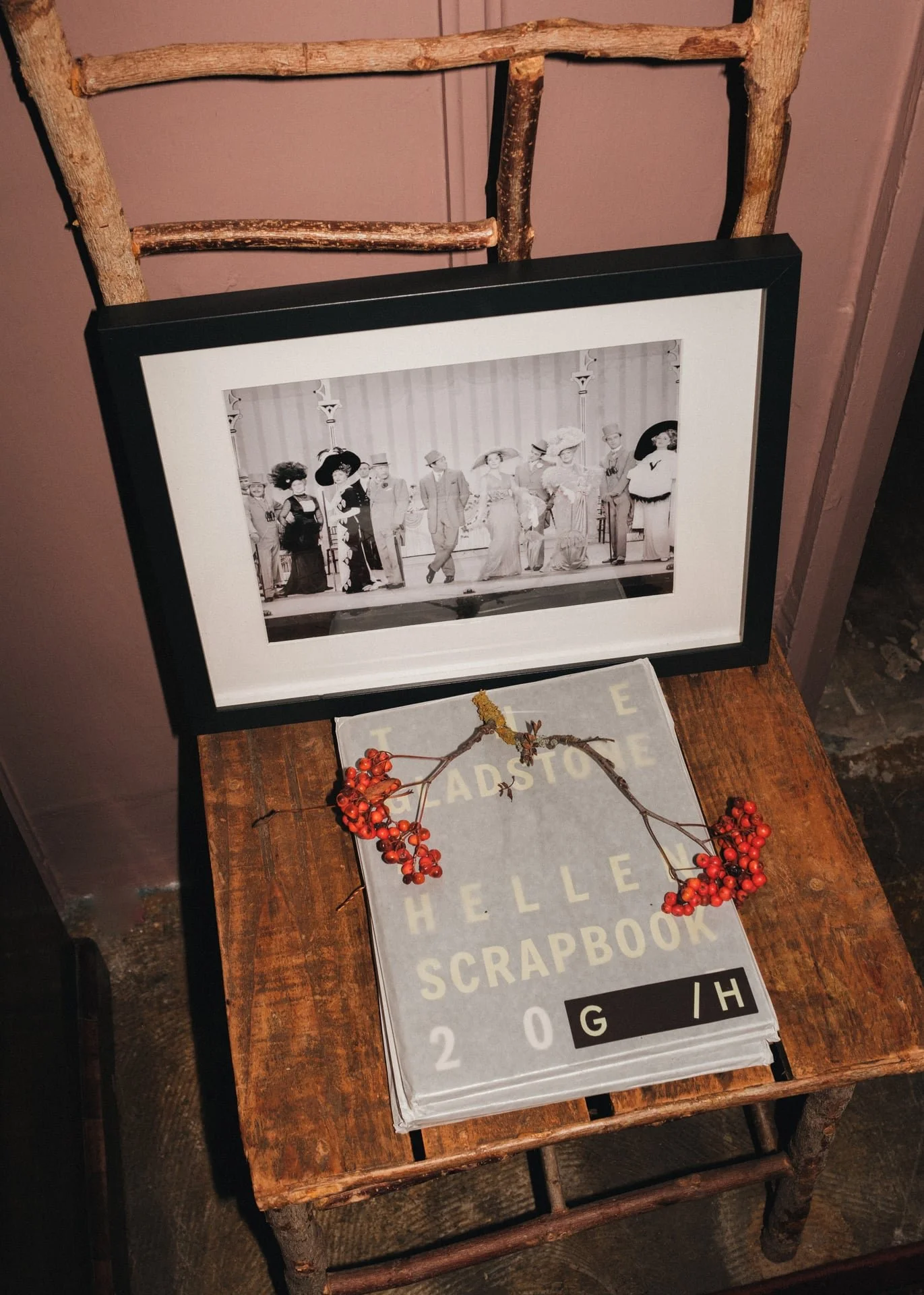 a black and white Cecil Beaton photo rests on a wooden chair above a coffee table book