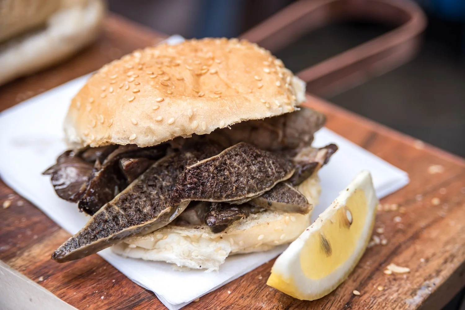 A spleen sandwich served with a silver of lemon in a Palermo market, Sicily