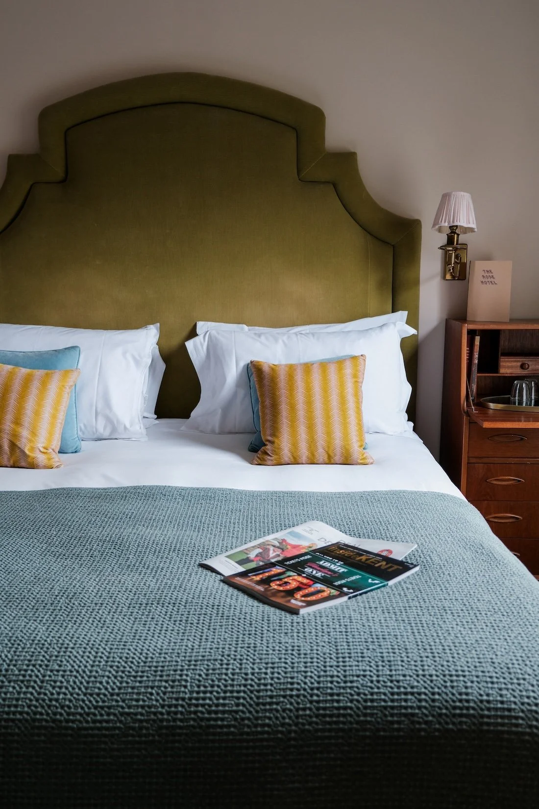 A close up of a ben with a green velvet headboard, and a patterned blue bedspread at The Rose, Deal