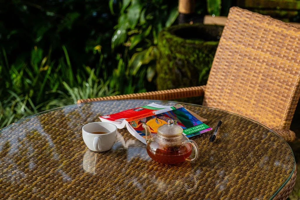 A table with tea and a book in the sun in Ubud, Bali