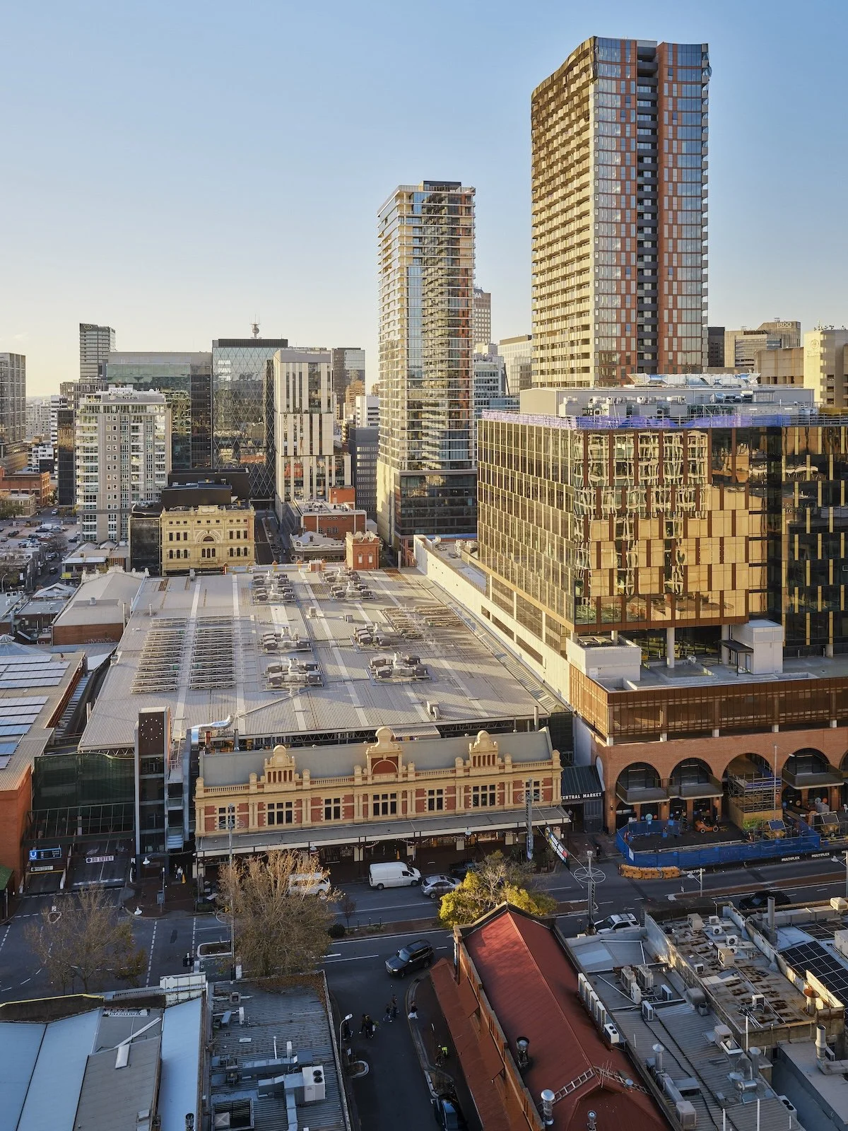 Looking out across the brick facade of the Adelaide Central Market with modern skyscrapers rising in the background