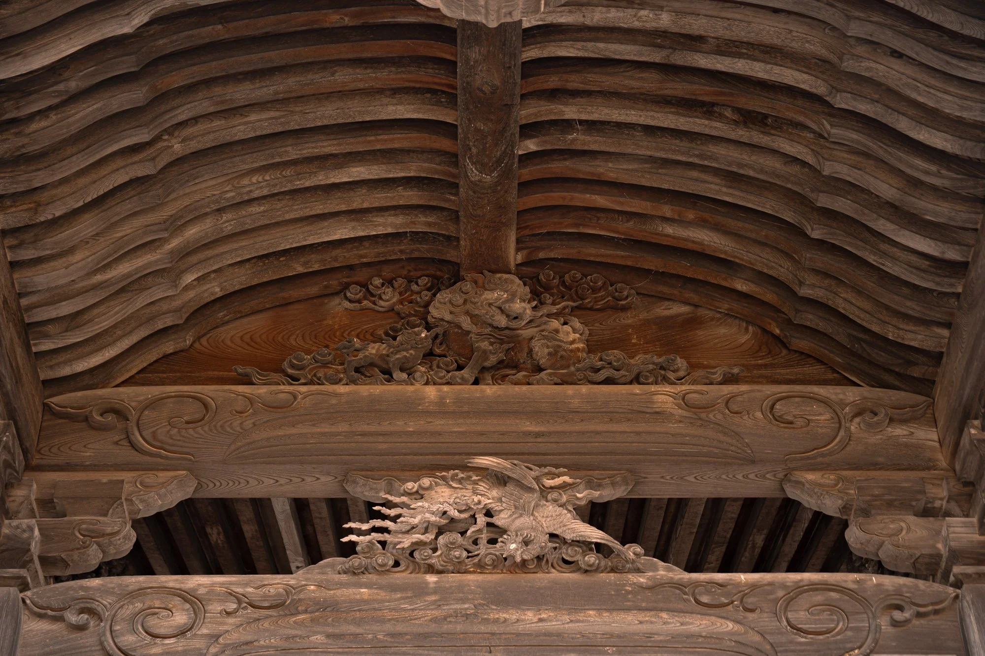 A close up of a temple carving in Japan, depicting a dragon emerging from the clouds
