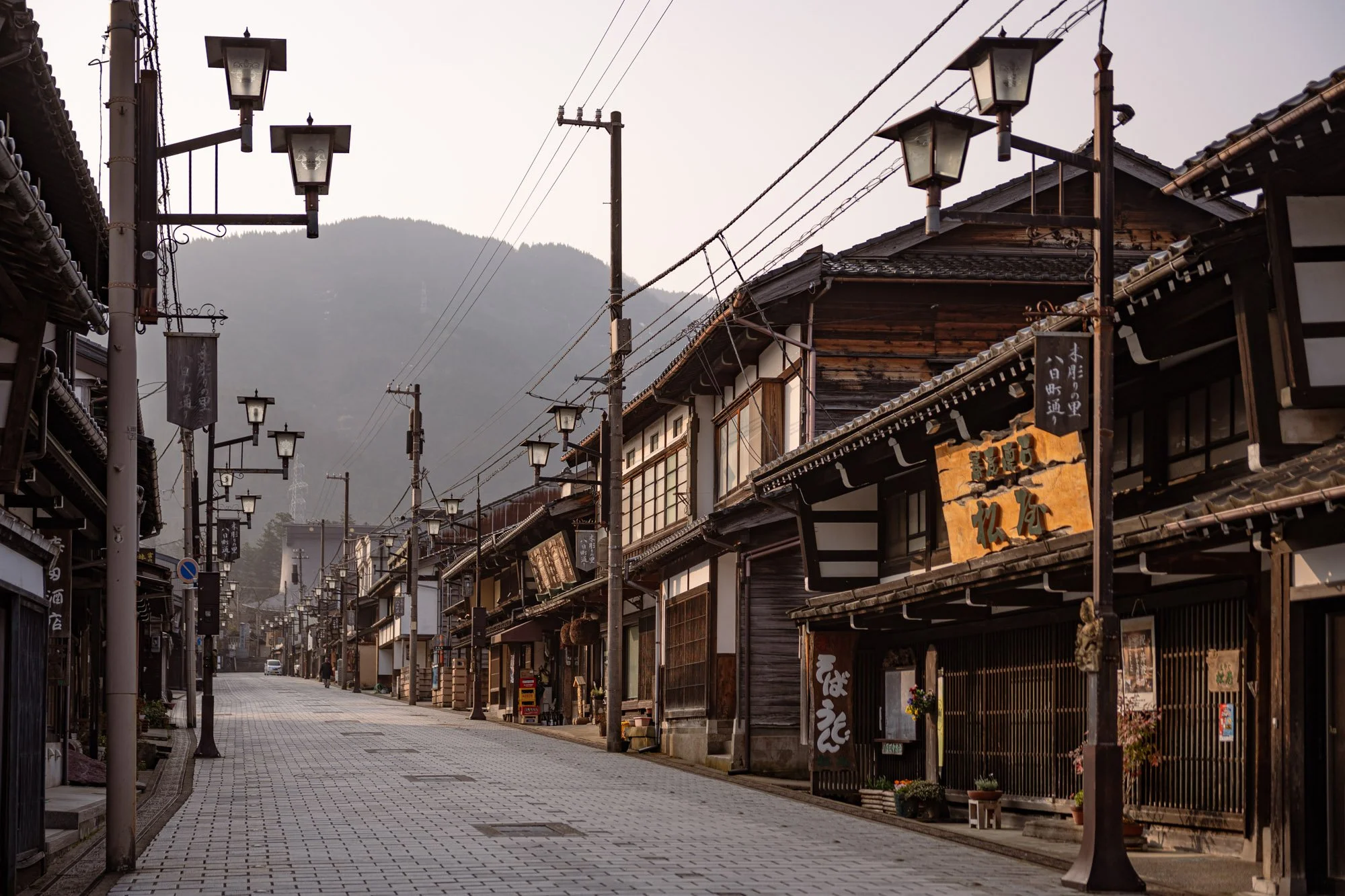 A paced Japanese street lined with lanterns and traditional houses, Inami, Toyama