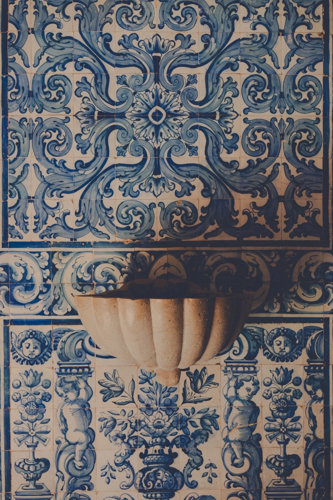 blue and white Portuguese tiles frame a stone basin
