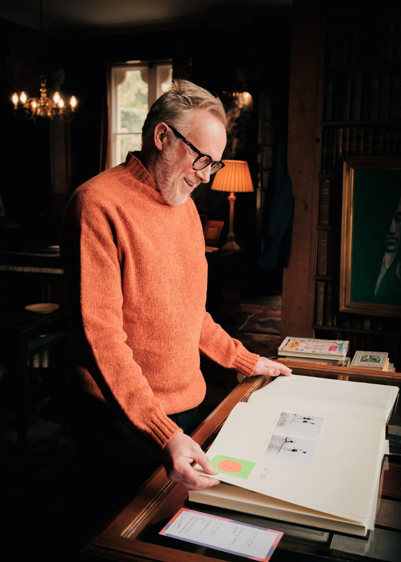 Charlie Gladstone stands inside a stately room in Hawarden Estate looking at photographs captured by Cecil Beaton