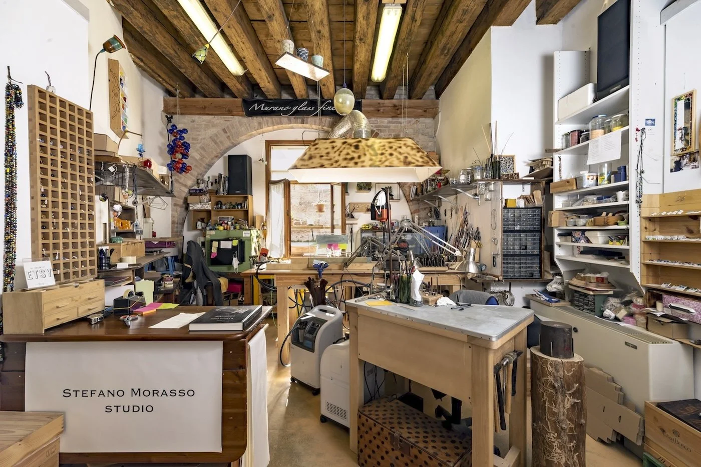 Natural light illuminates a glass artists studio in Venice. the walls are full of his tools and sculptures