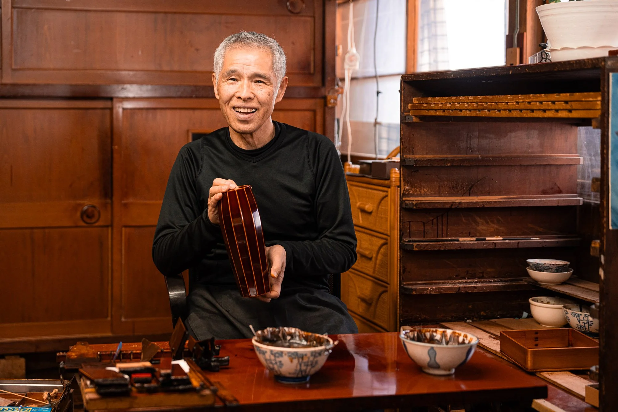 Lacquer artist Kumazaki with his Hida Shunkei vase, sitting in his wooded studio in Japan
