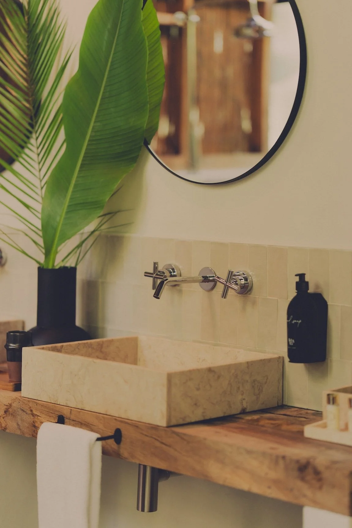 A cream tiled bathroom sink and mirror at the luxury hotel, Salvaterra Country House & Spa in central Portugal