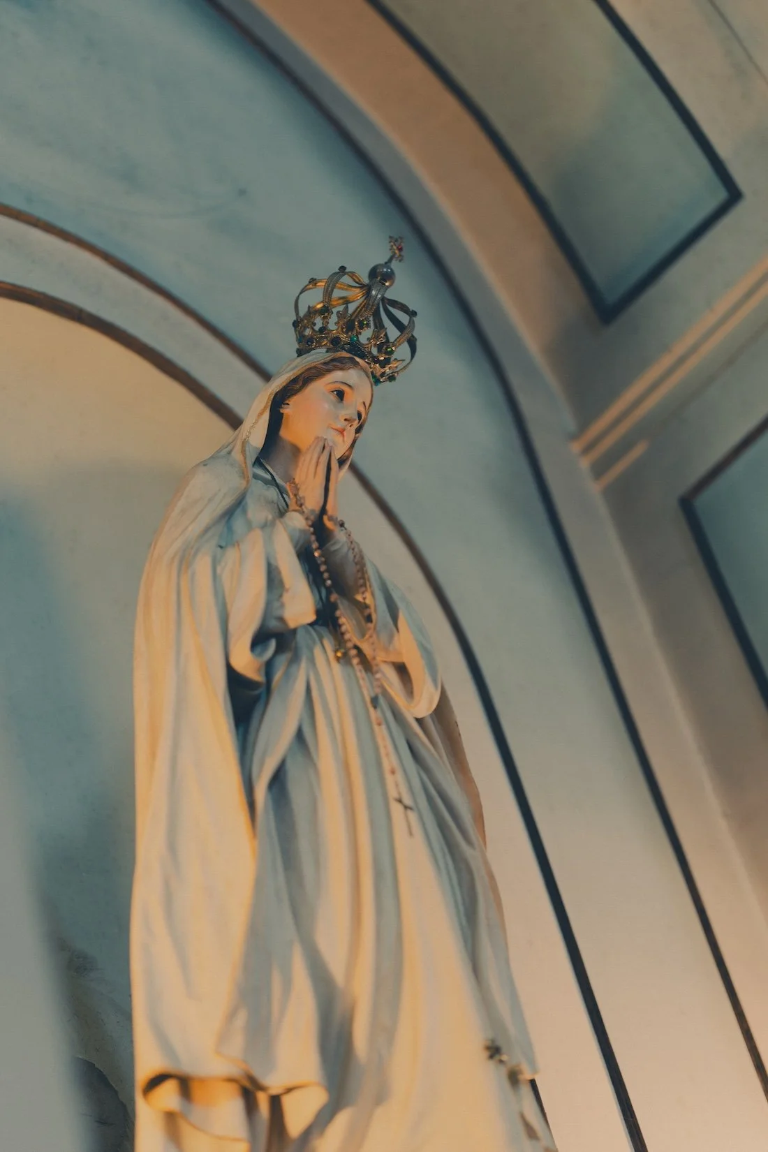 A statue of the Madonna in the blue and while alcove of a small Portuguese church