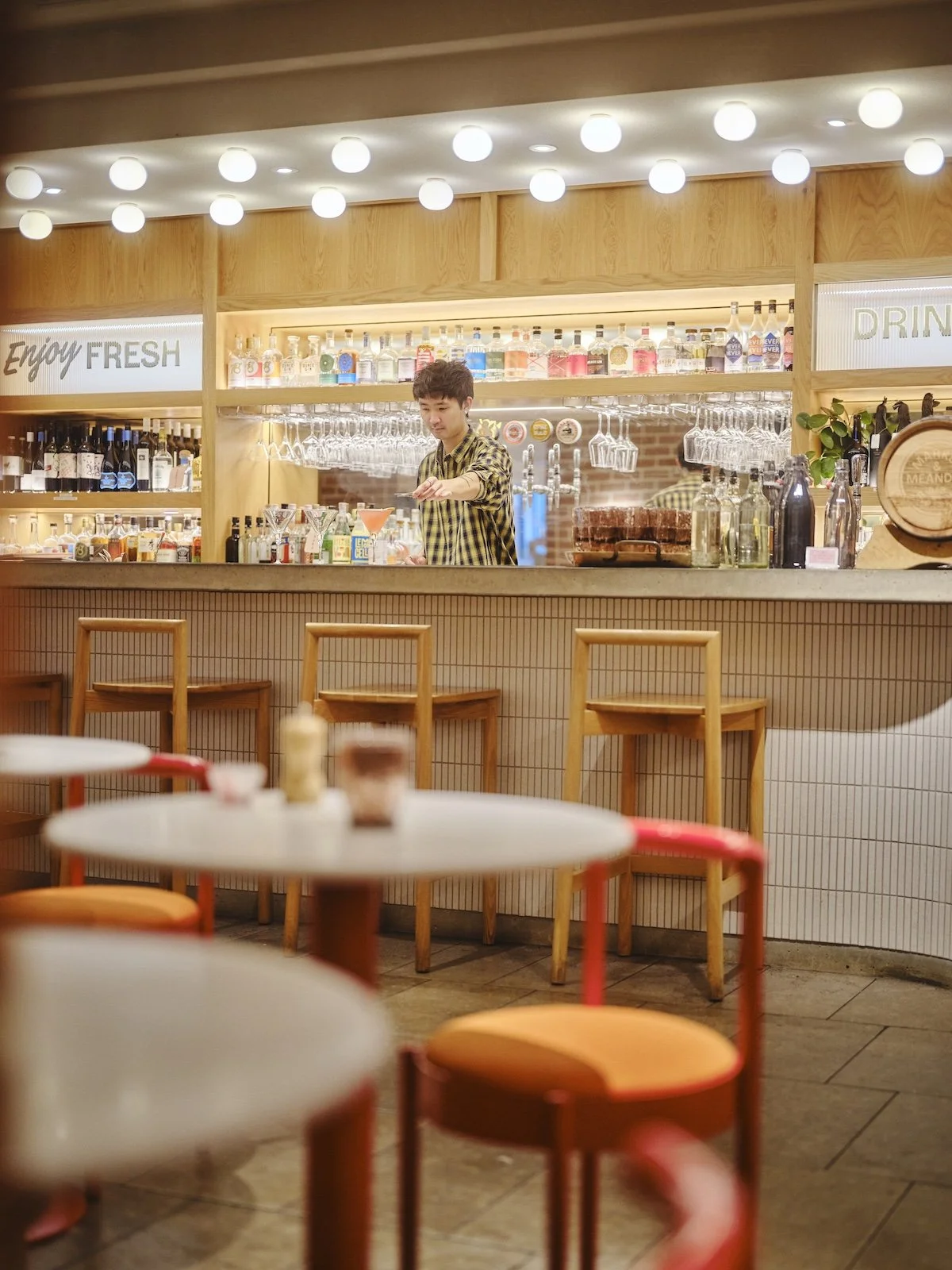 A bartender mixes cocktails at the bar in Hotel Indigo Adelaide Markets