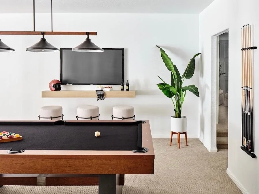 pool table with plush bar stools and house plant
