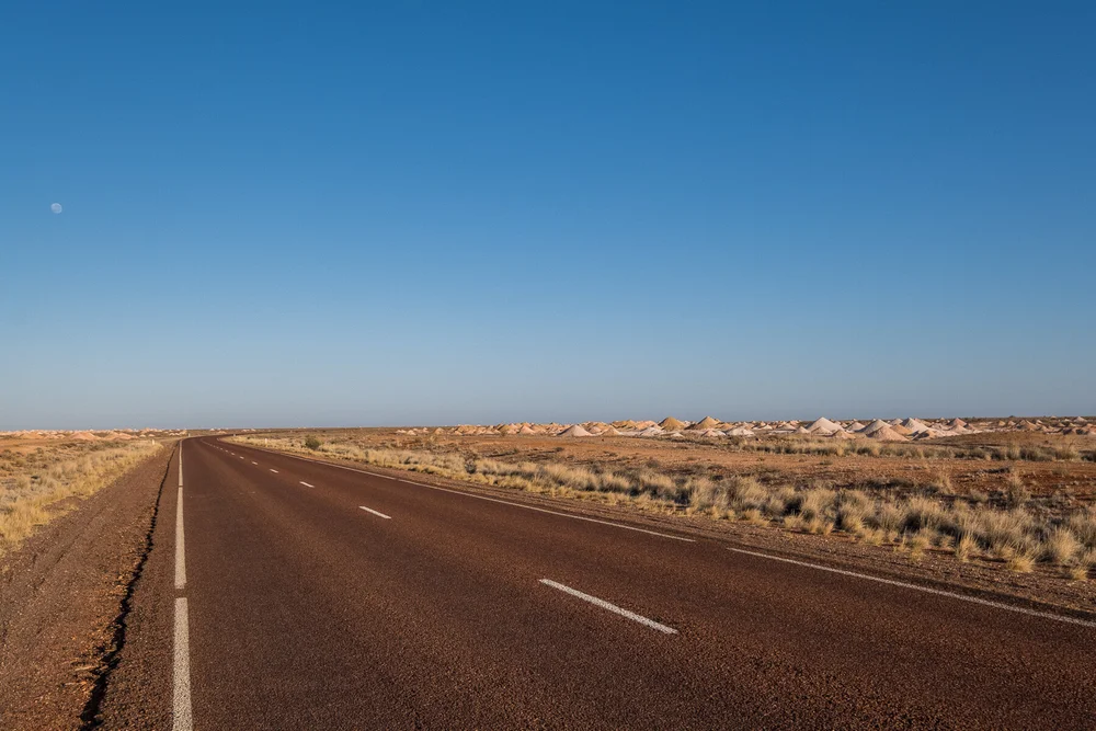  Coober Pedy produces the bulk of the world's white opal. The opal mining fields of Coober Pedy lie in the outback of South Australia, Stuart Range, 750 km north of Adelaide. 